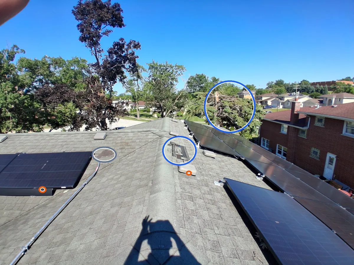Missing shingles, and dents in the gutters or other soft metal, a tree or debris impact, circled on a C&N Construction job photo in the Chicago suburbs