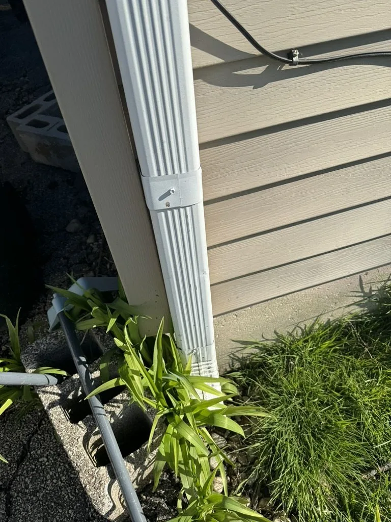 Ground-level view of downspout during storm damage assessment