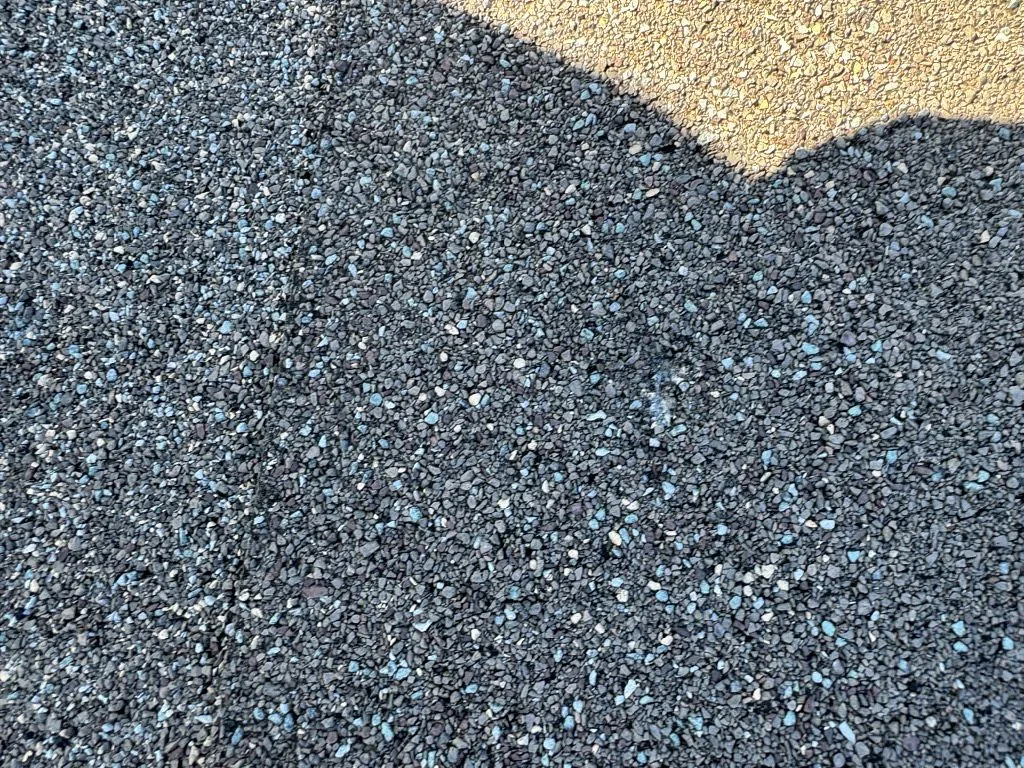 Shingle granule comparison showing intact coverage next to areas of loss