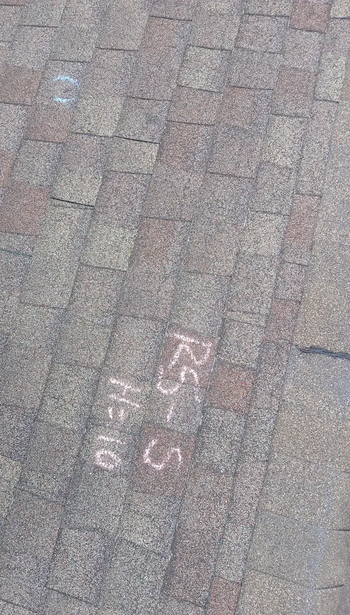Chalk on a gray shingle roof reading RS-S, H=10