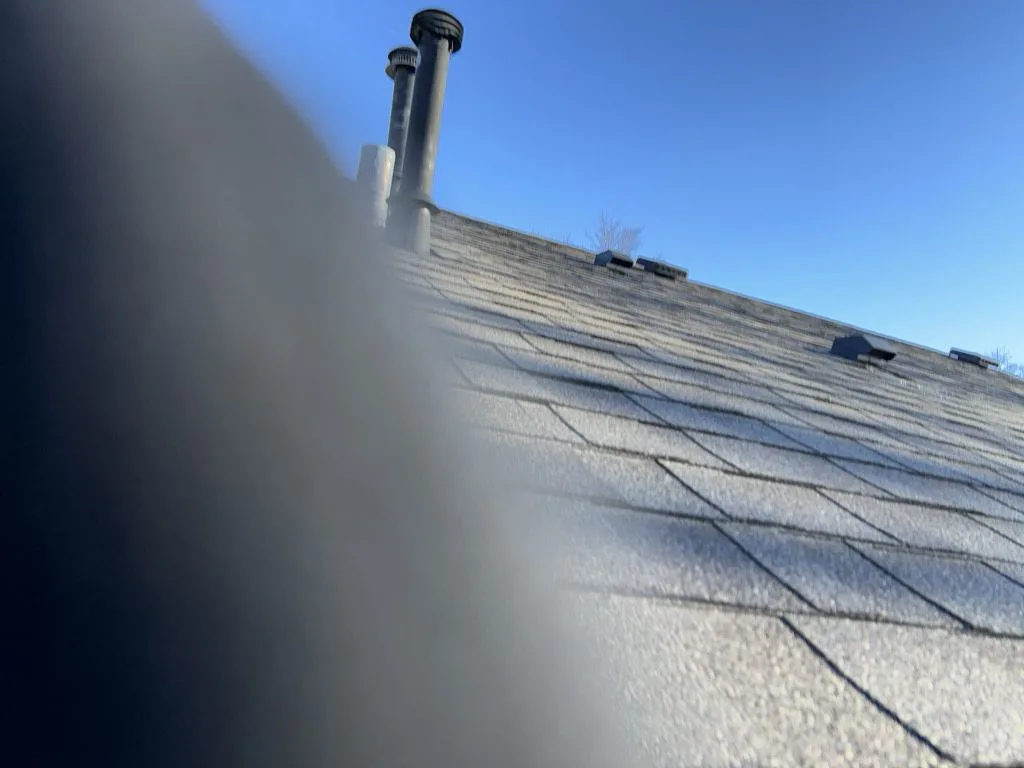 Residential roof surface showing shingle condition and vents