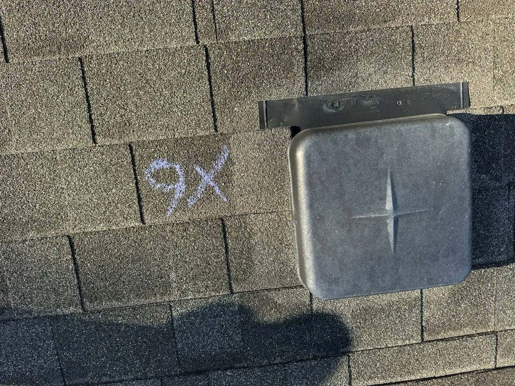Chalk marks on roof documenting hail damage count during inspection