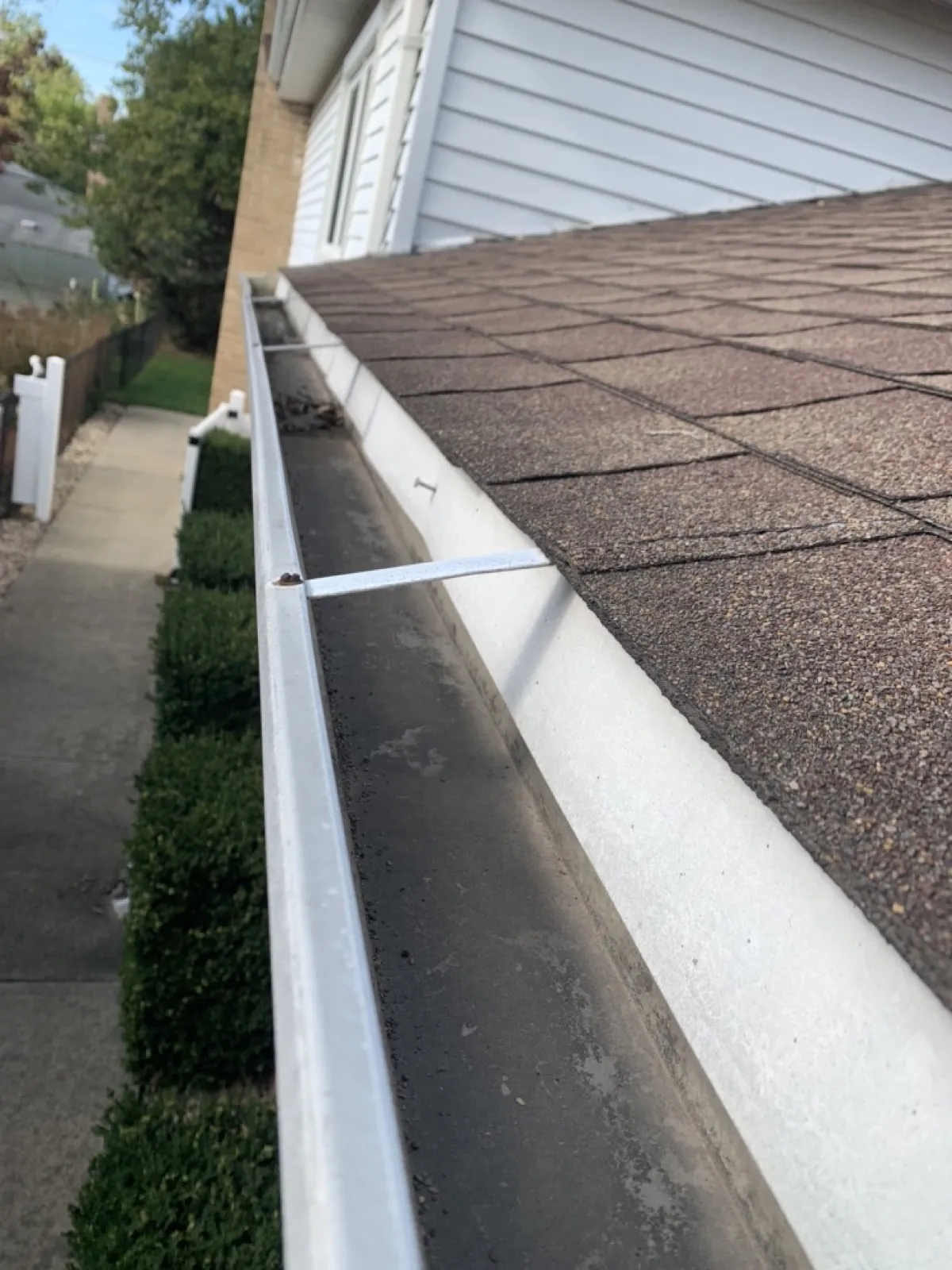 New white aluminum gutters installed on a shingled roof in Addison, IL