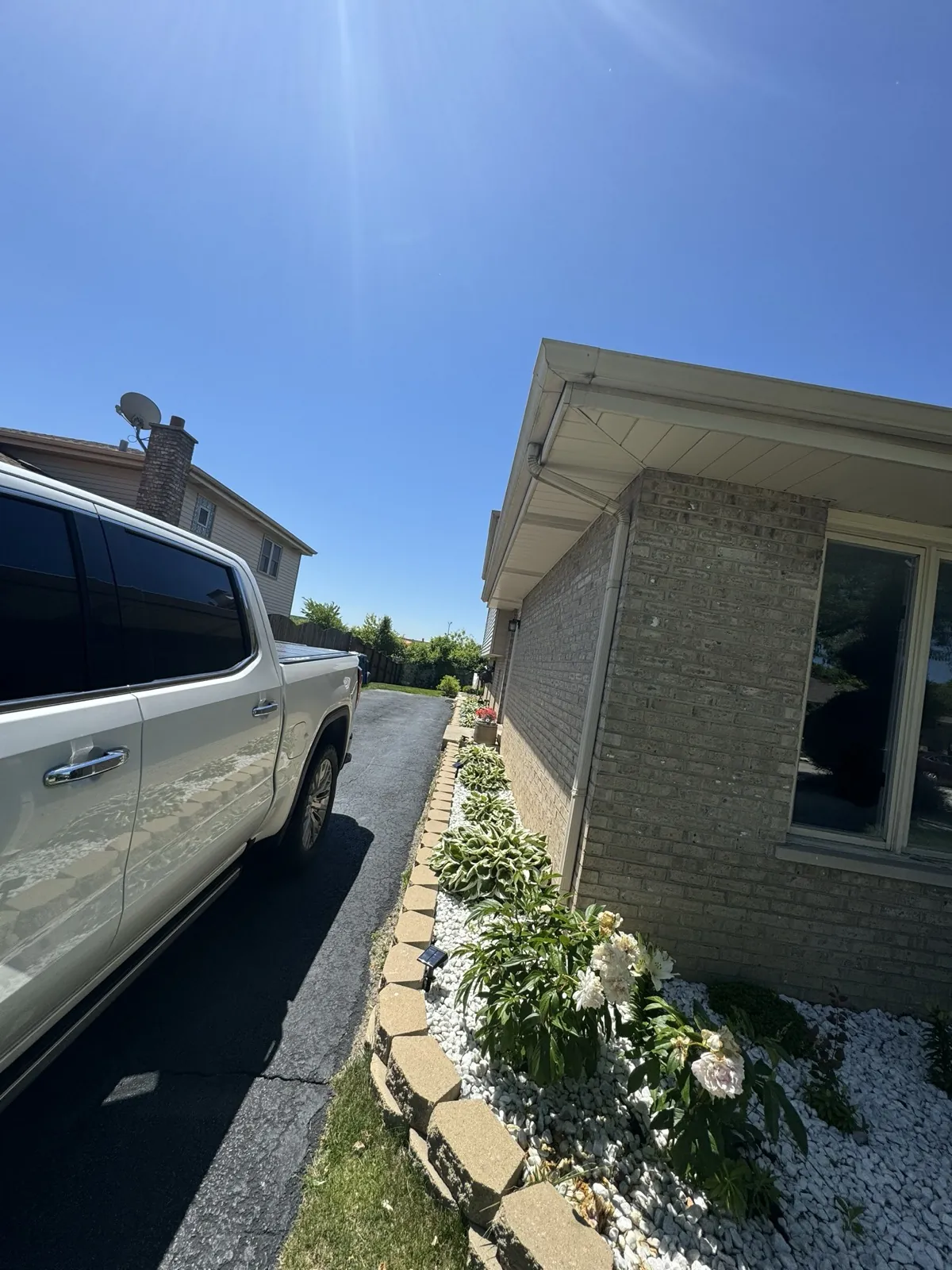A view of a home's exterior featuring a white gutter system and brick siding in Alsip, IL