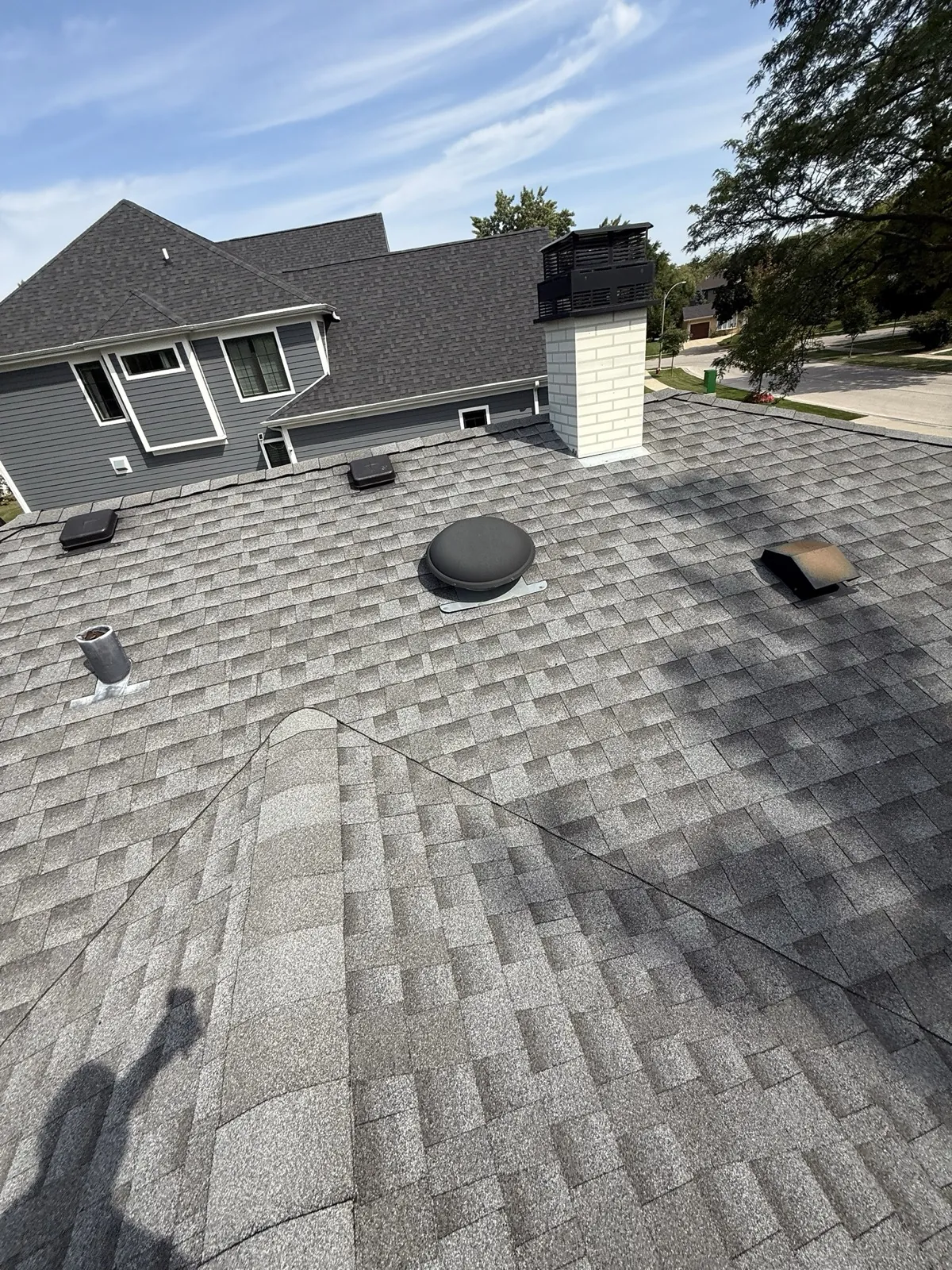 New charcoal gray architectural shingle roof on a multi-level home in Arlington Heights, IL