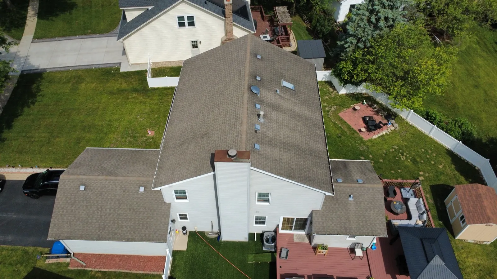 Aerial view of a new brown architectural shingle roof on a large residential home in Bartlett, IL