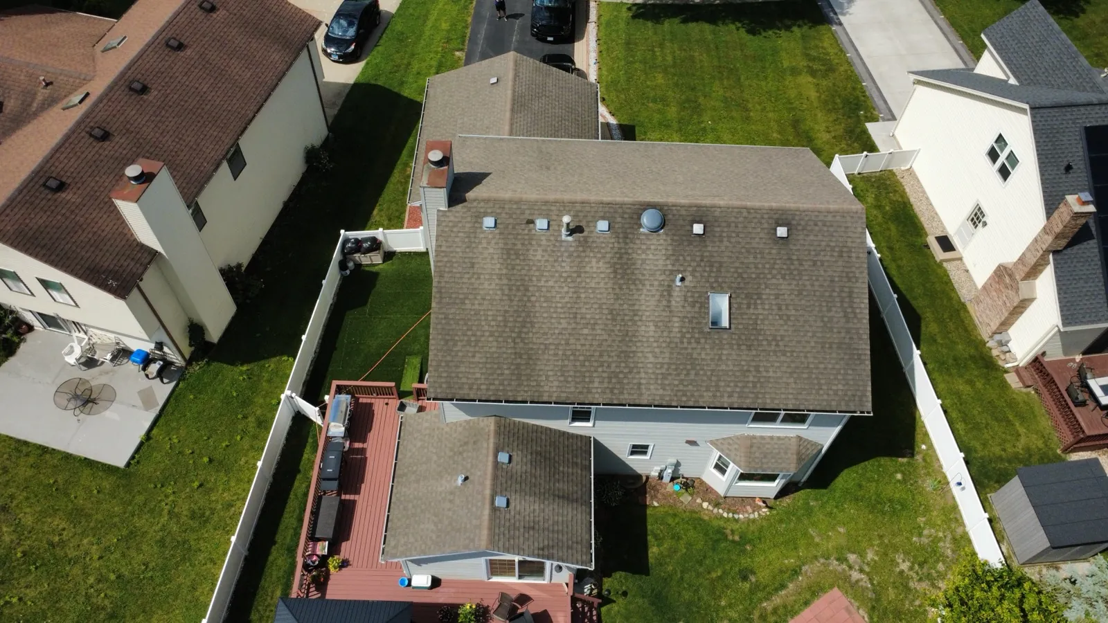 Aerial view of a new brown asphalt shingle roof on a large residential home in Bartlett, IL