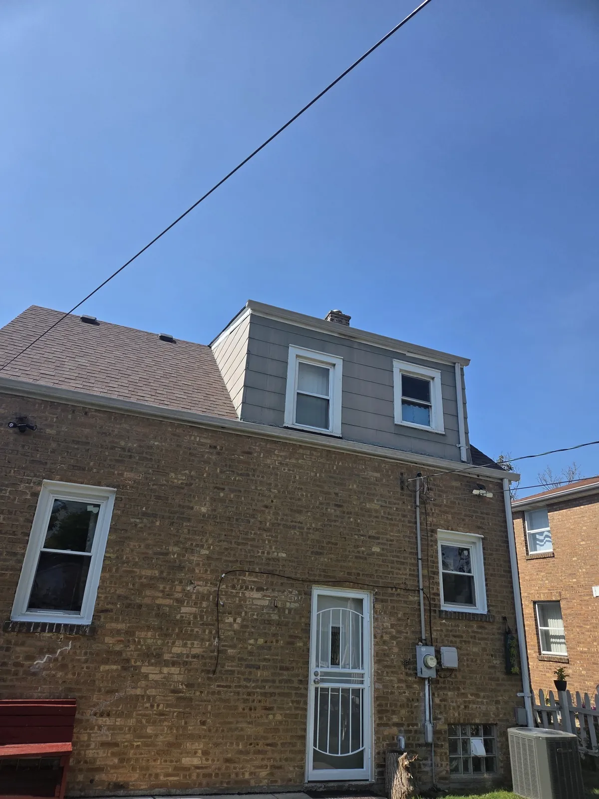 New gray fiber cement siding installed on a multi-story brick building in Bellwood, IL