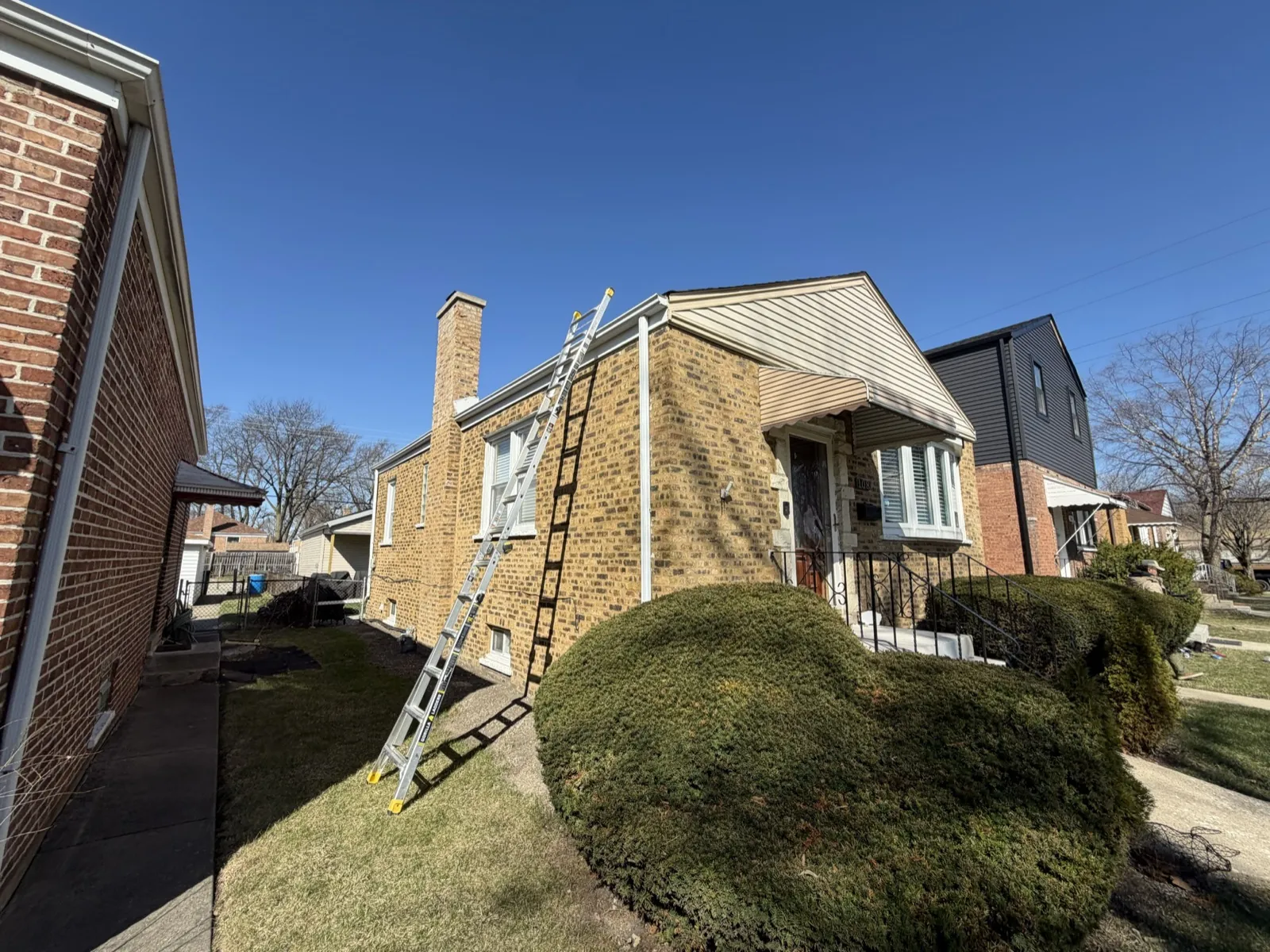 A ladder is positioned against a house for roof work in Bellwood, IL