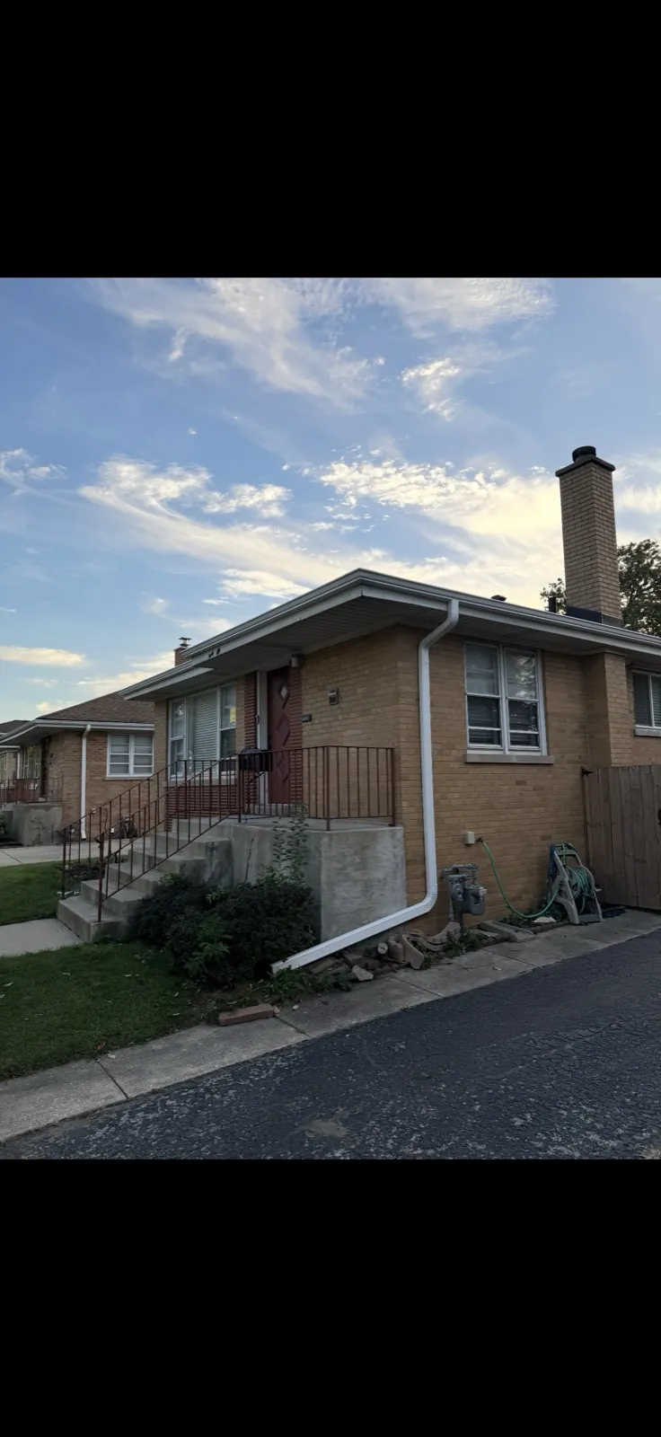 White gutters and downspouts installed on a brick bungalow in Berkeley, IL