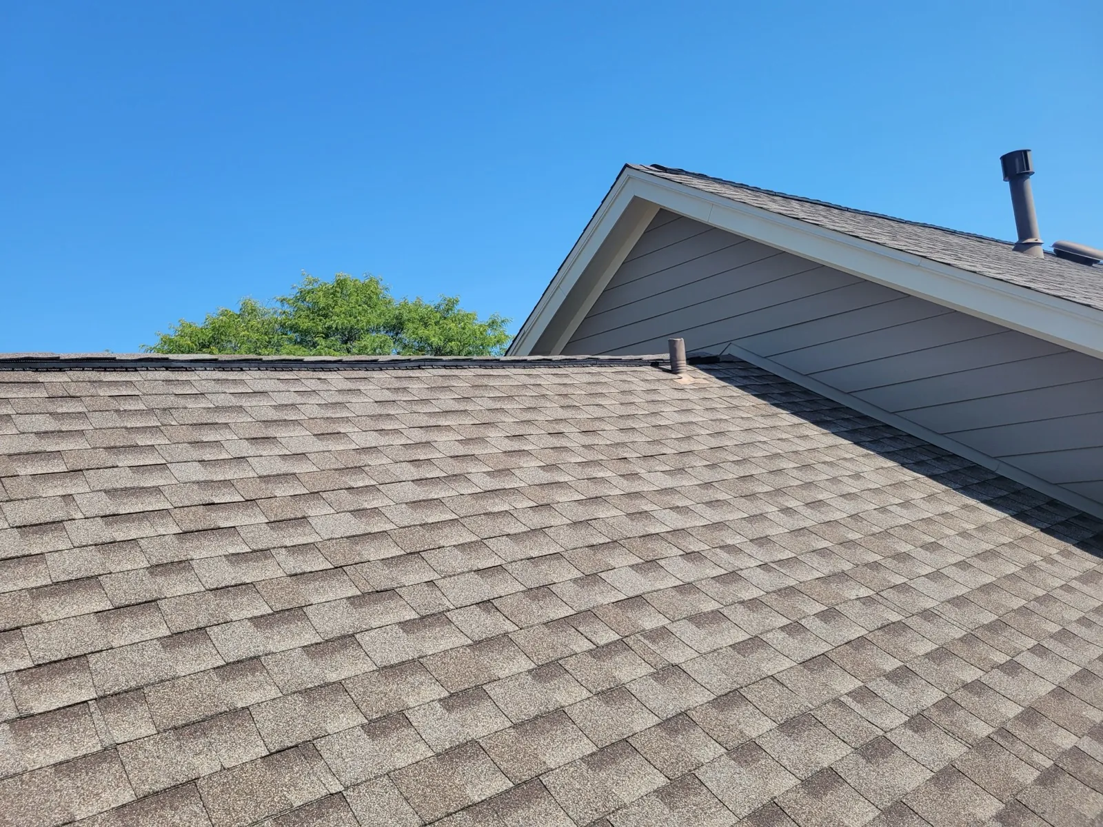 New gray architectural shingle roof on a home with horizontal siding in Burr Ridge, IL