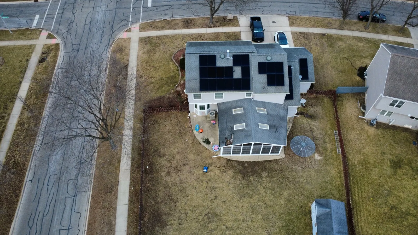 Aerial view of a new gray asphalt shingle roof with integrated solar panels in Carol Stream, IL