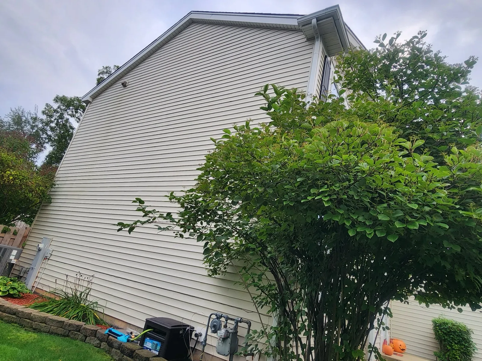 New beige vinyl siding installed on the side of a house in Carpentersville, IL