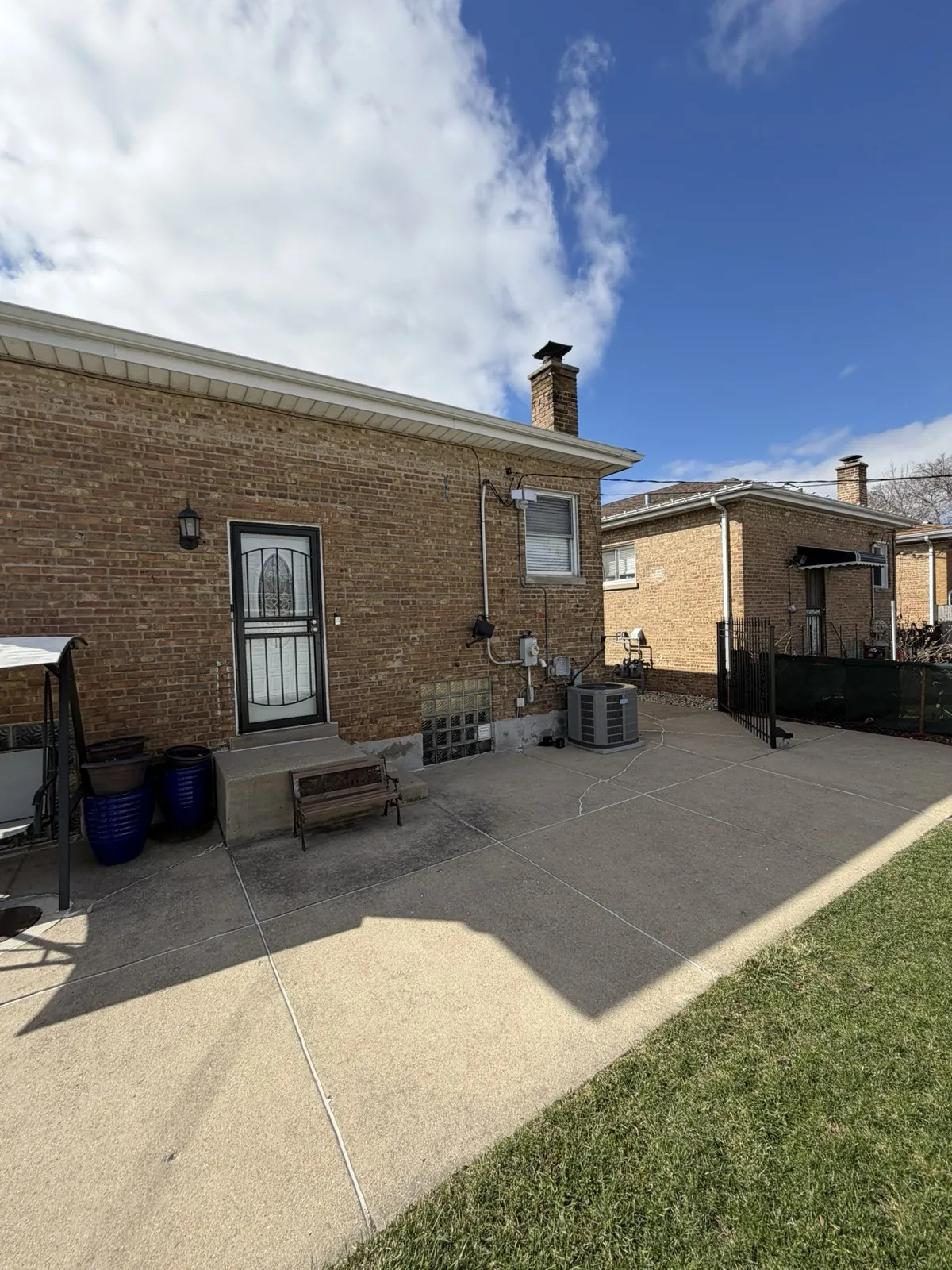 A brick home with a finished exterior and a paved patio in Cicero, IL