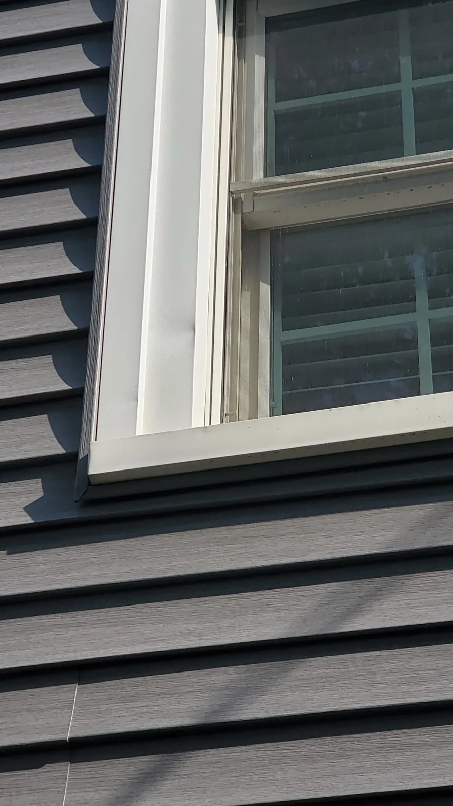 Gray fiber cement siding installed around a window in Clarendon Hills, IL