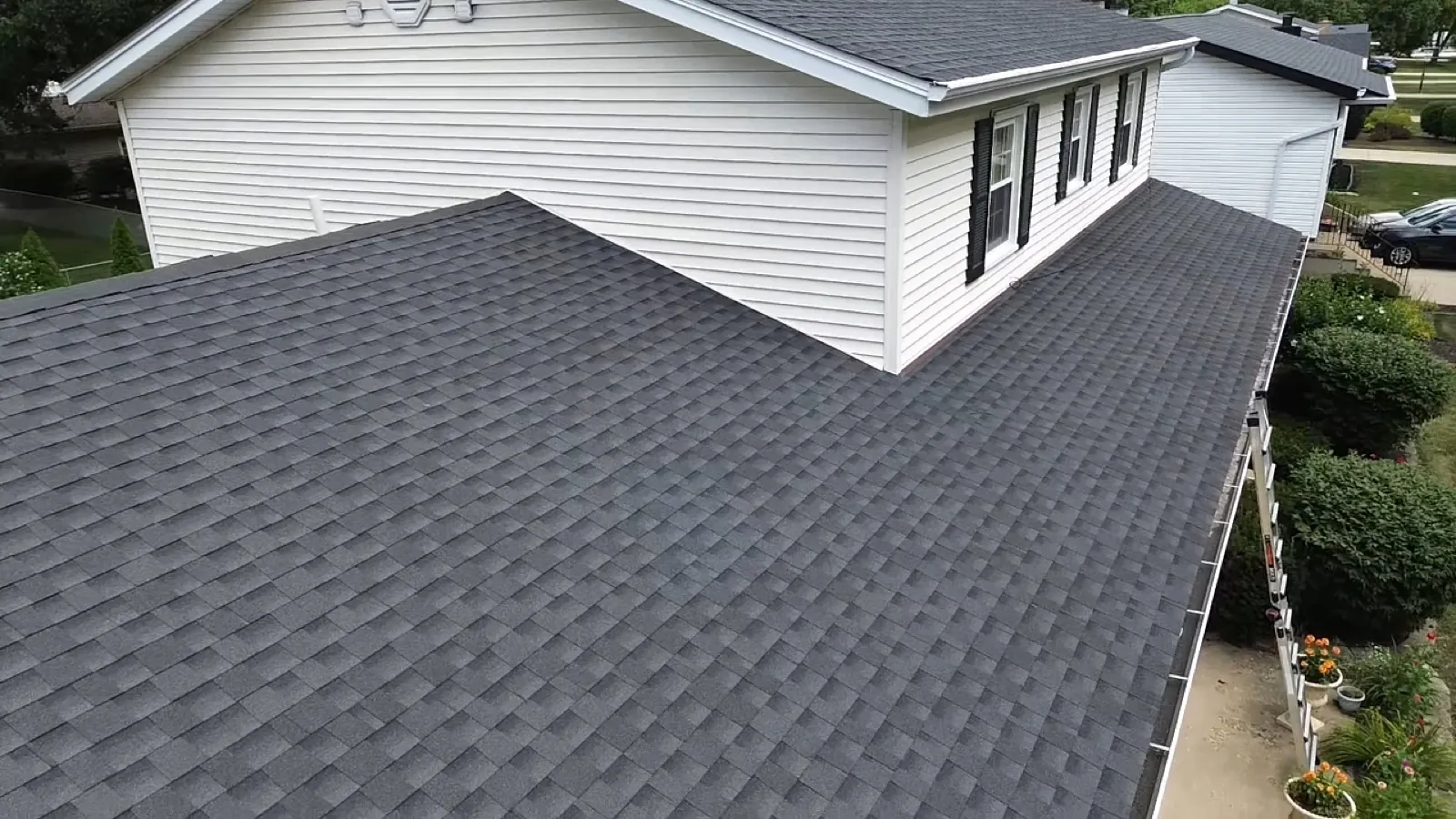 New charcoal gray architectural shingle roof on a white sided home in Darien, IL