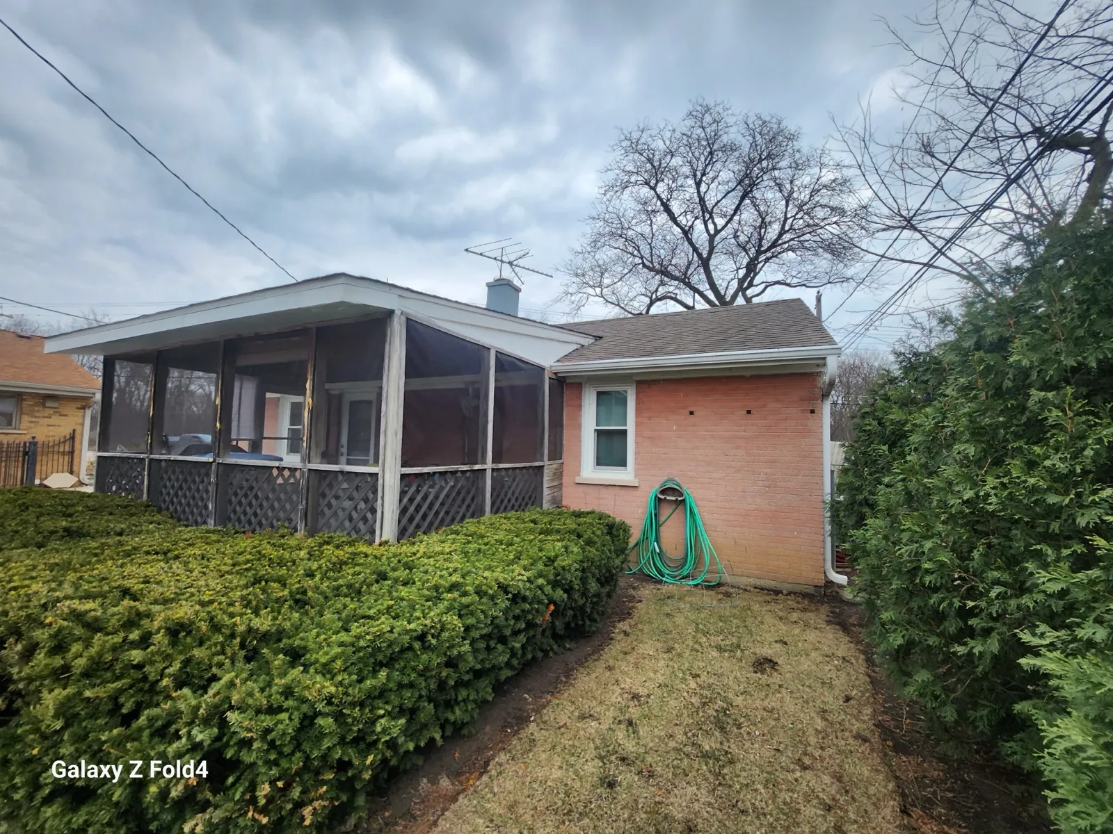 A new asphalt shingle roof on a brick house with a screened-in porch in Des Plaines, IL