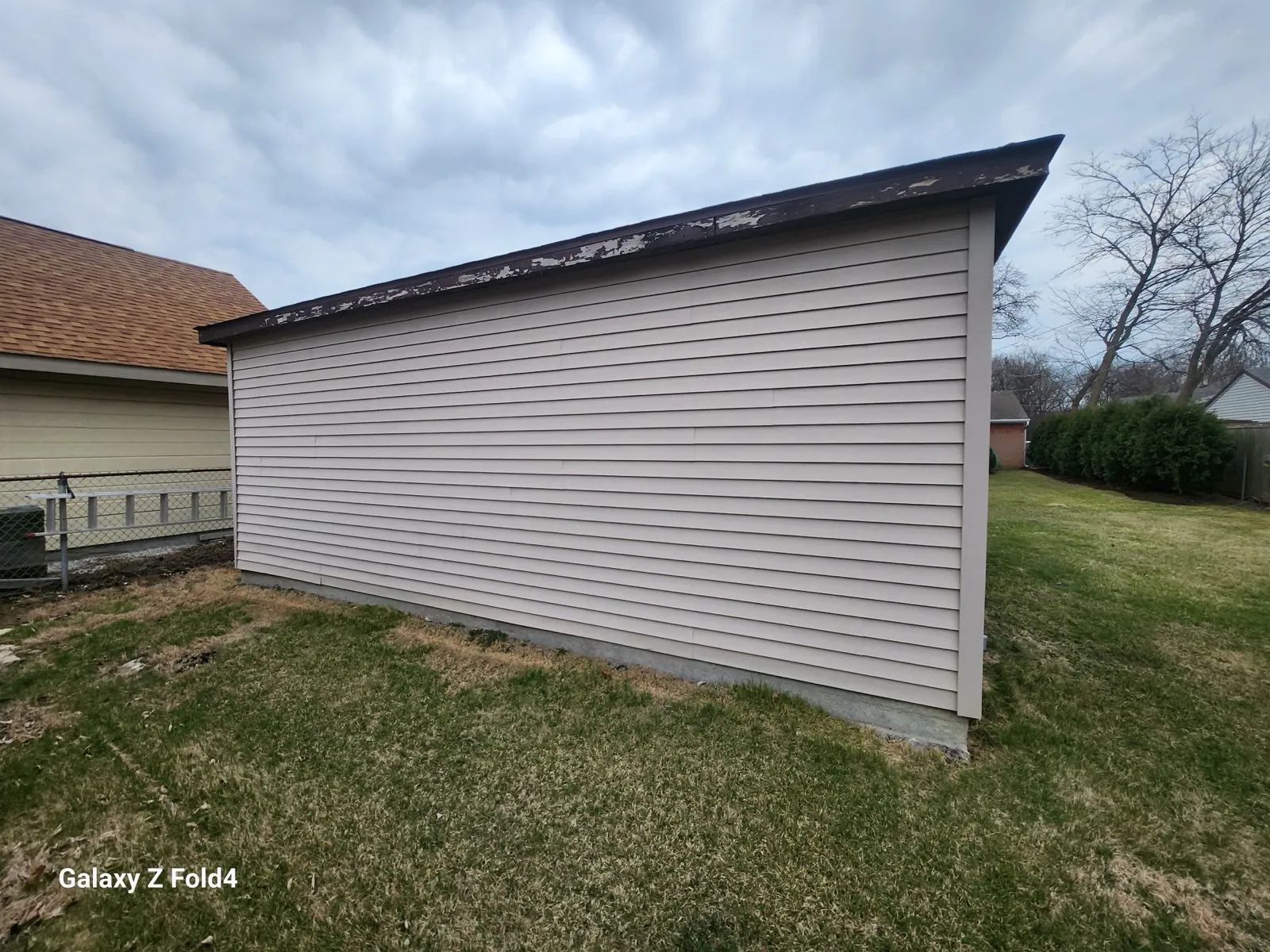 A view of a new asphalt shingle roof and vinyl siding on a residential building in Des Plaines, IL