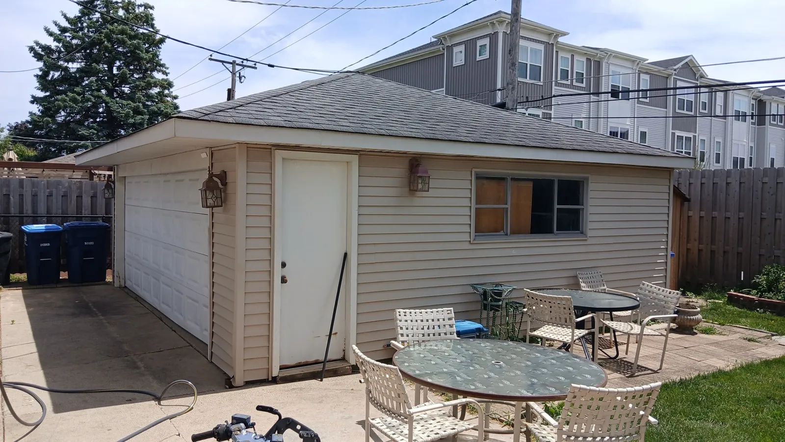 A gray asphalt shingle roof on a small outbuilding with siding in Des Plaines, IL