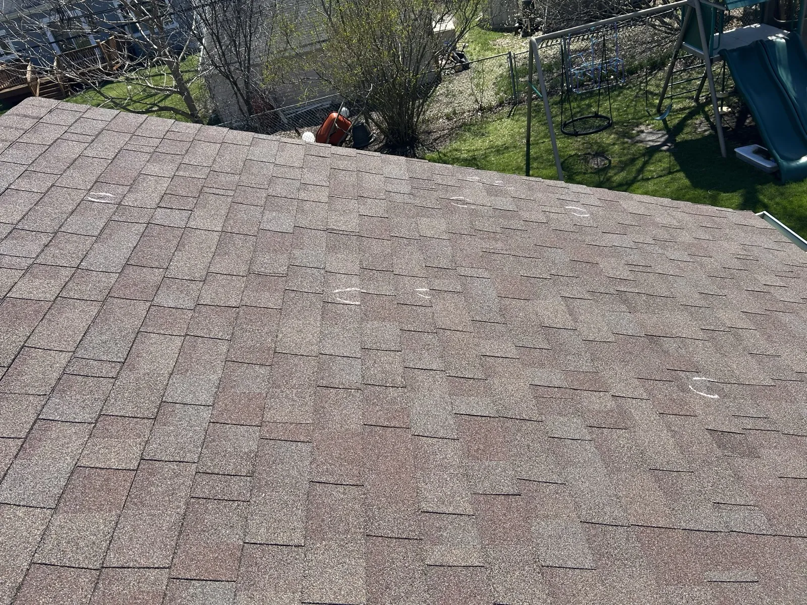 A close-up view of a new asphalt shingle roof installation with chalk markings for layout in Downers Grove, IL