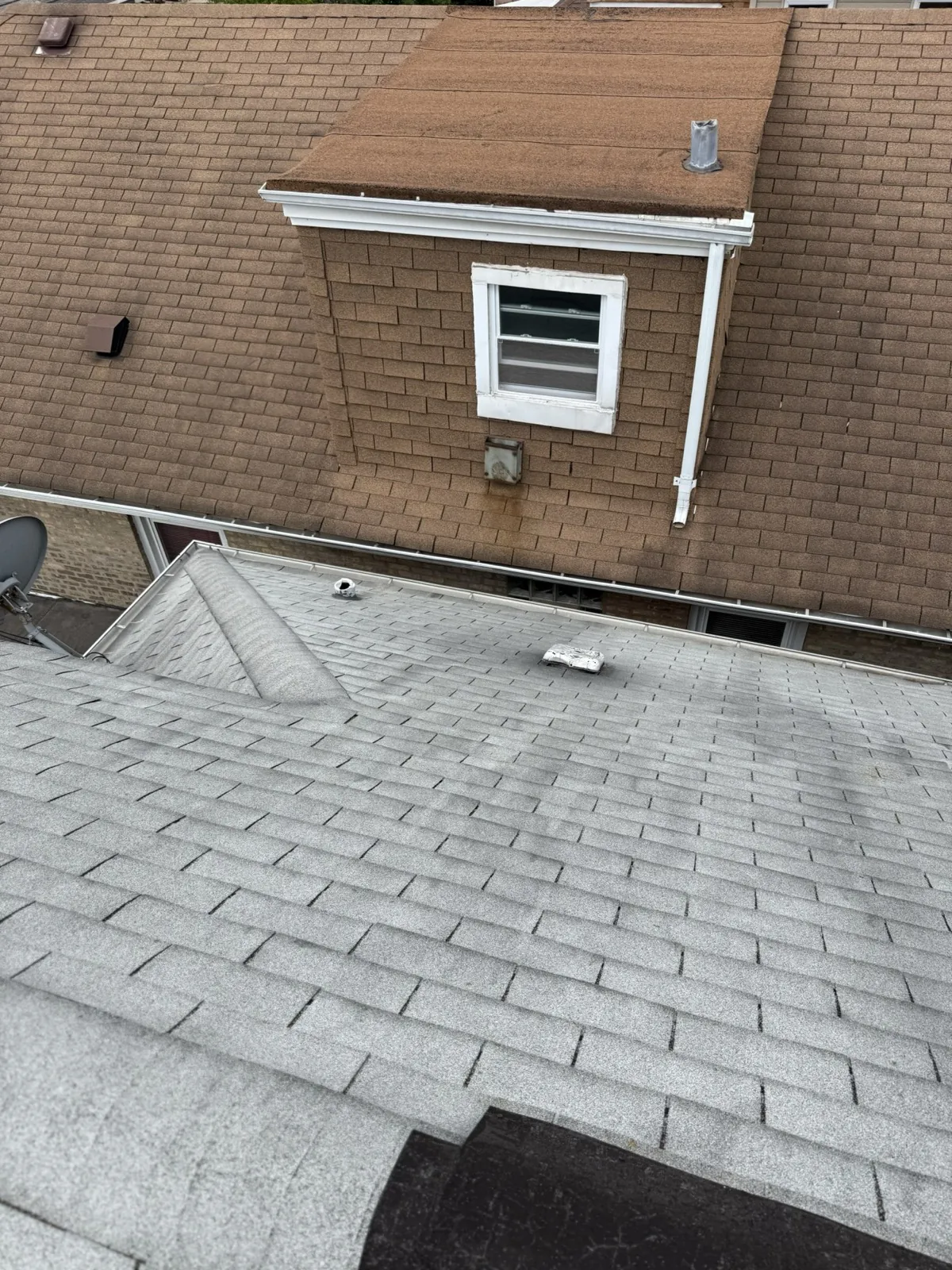 A gray asphalt shingle roof with a dormer window in Elmwood Park, IL