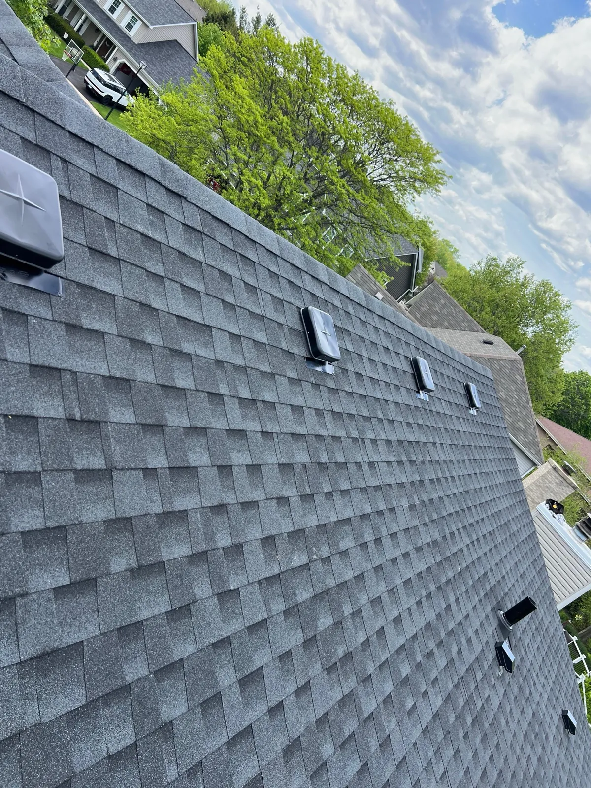 New charcoal gray architectural shingle roof with installed skylights in Geneva, IL