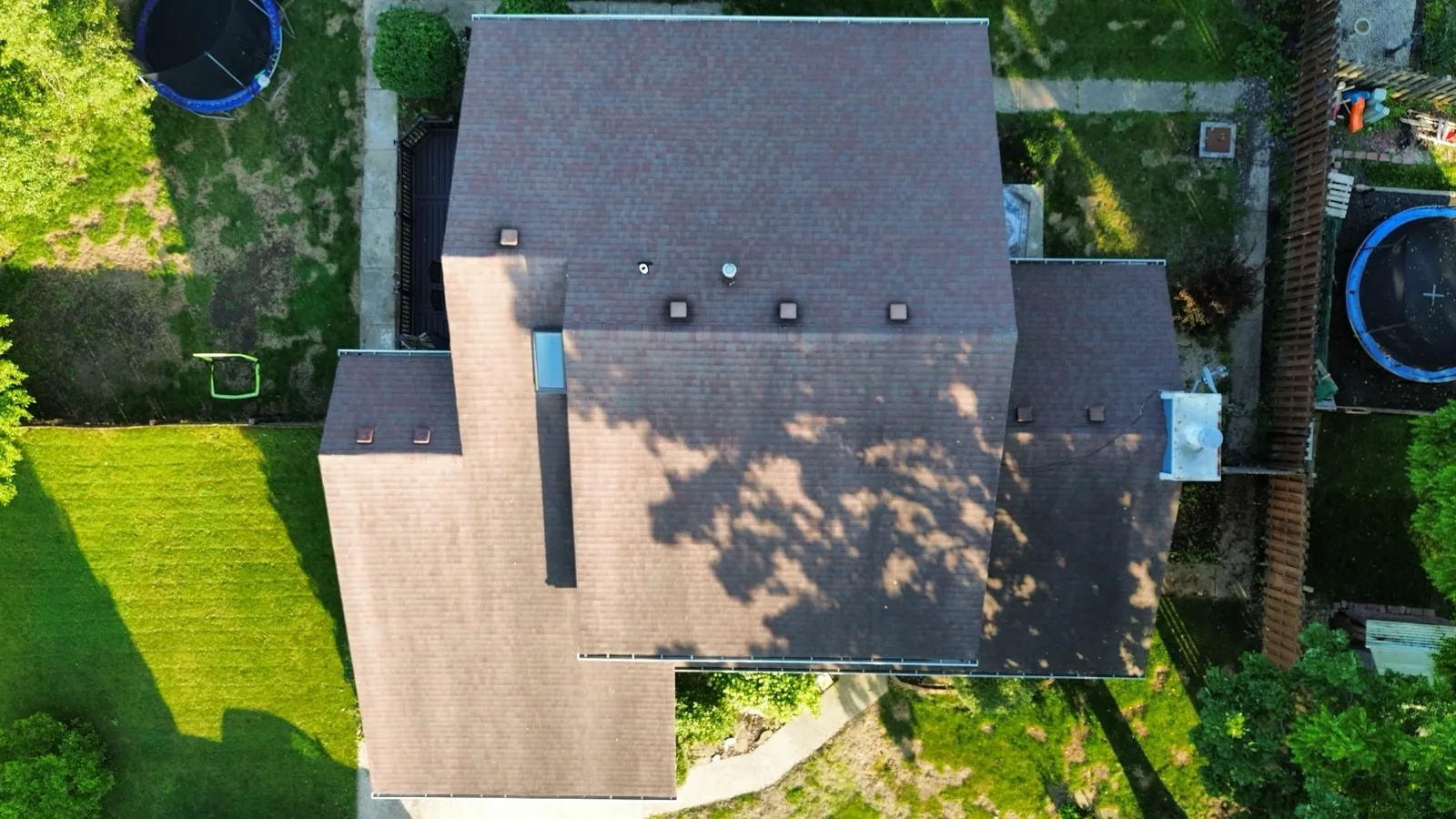 Aerial view of a new brown asphalt shingle roof on a large residential home in Gurnee, IL