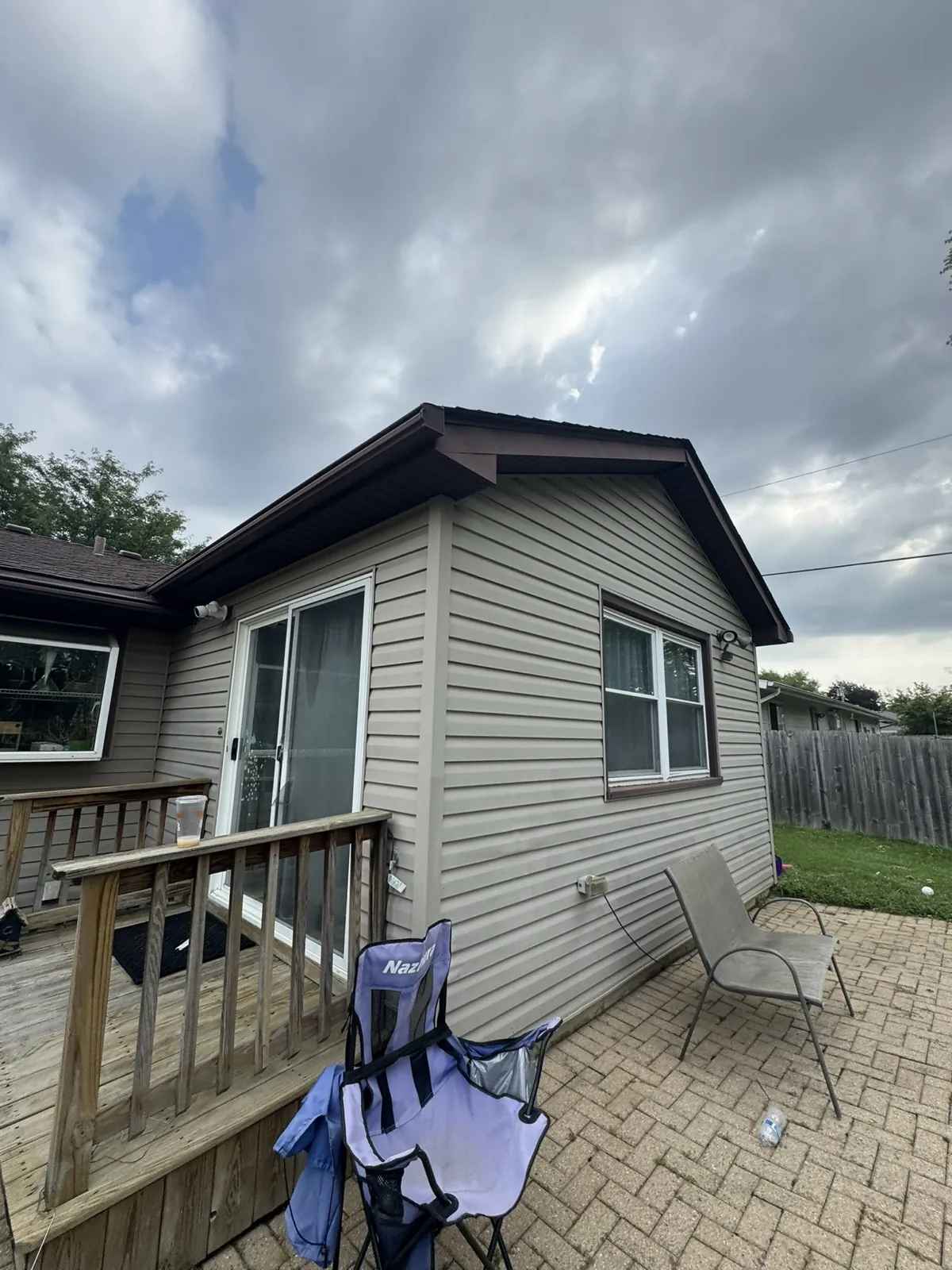 A dark brown asphalt shingle roof on a house with tan siding in Joliet, IL