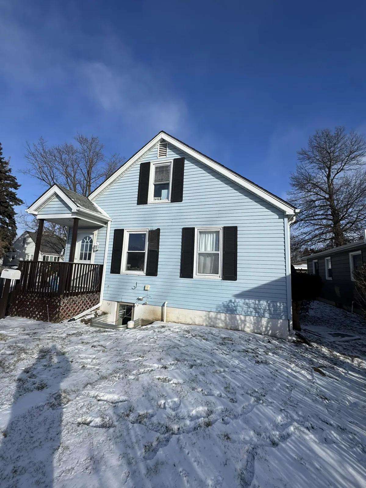 Light blue vinyl siding on a two-story home with black shutters in Joliet, IL