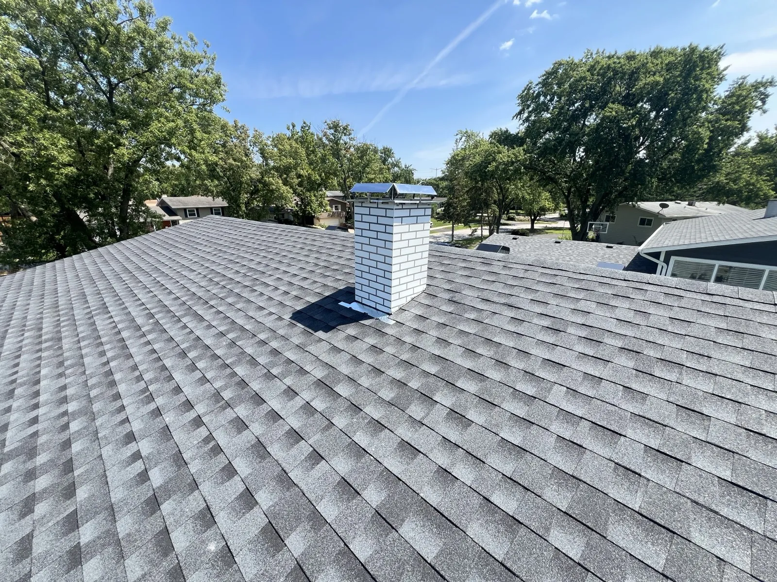 New gray architectural shingle roof with a white brick chimney in Lisle, IL