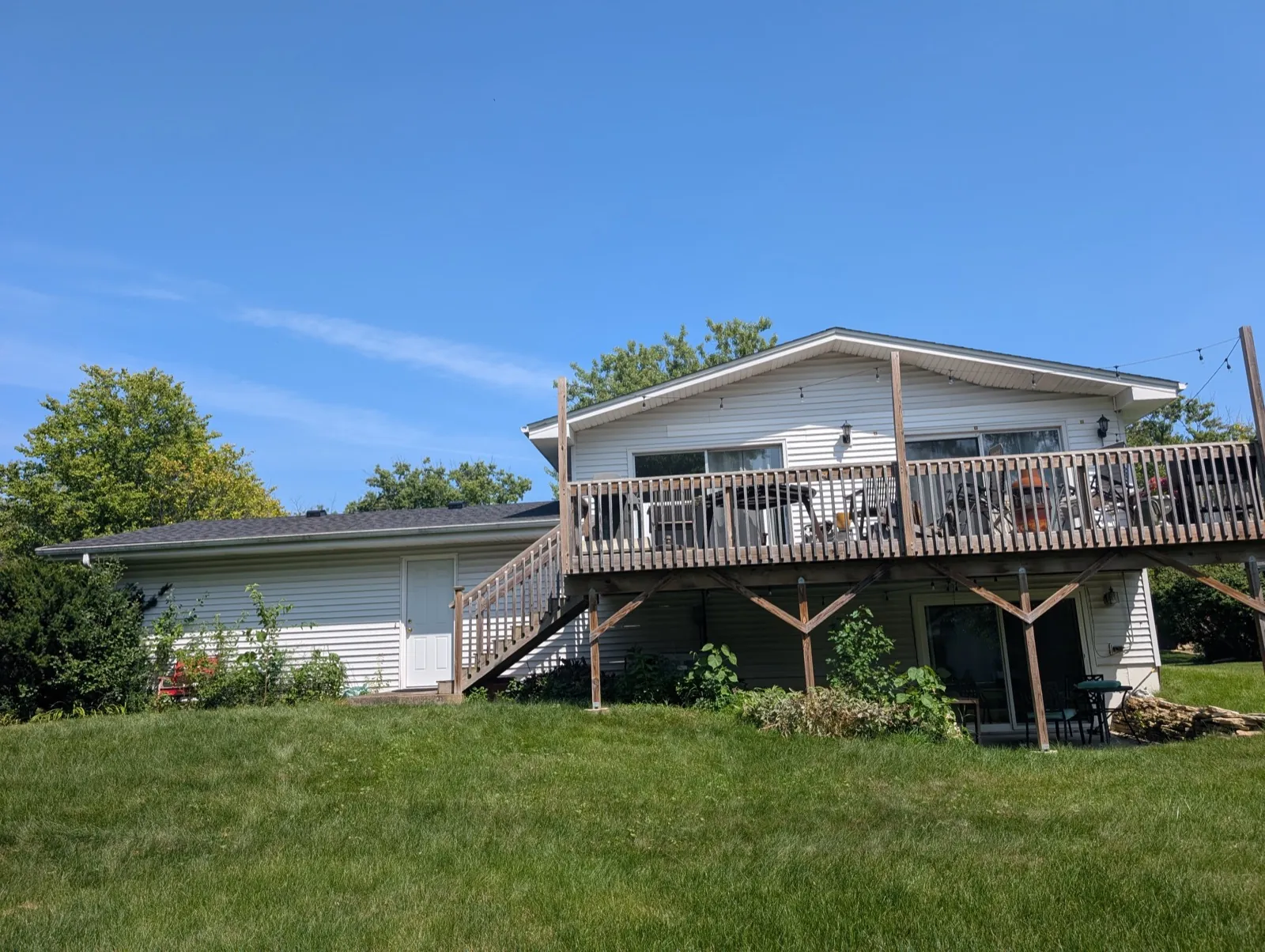 A new asphalt shingle roof on a white-sided home with a large wooden deck in Lisle, IL