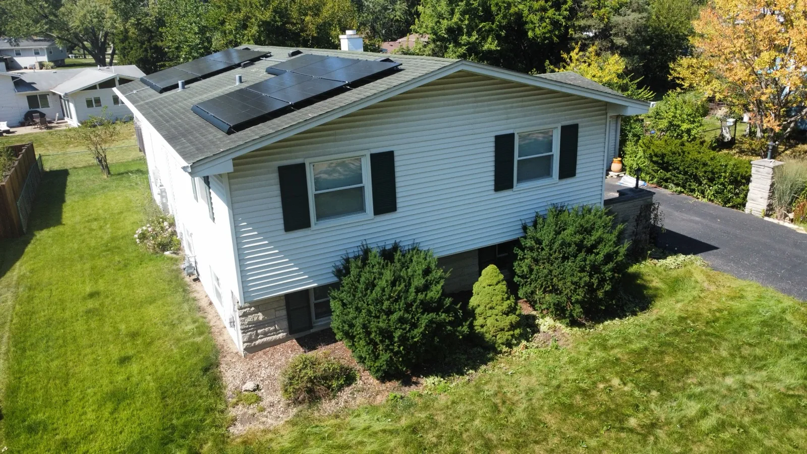 New asphalt architectural shingle roof with solar panels on a white sided home in Lisle, IL