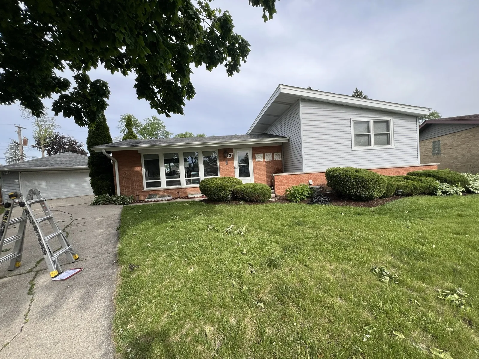 A split-level home featuring a new asphalt shingle roof and light gray siding in Lombard, IL