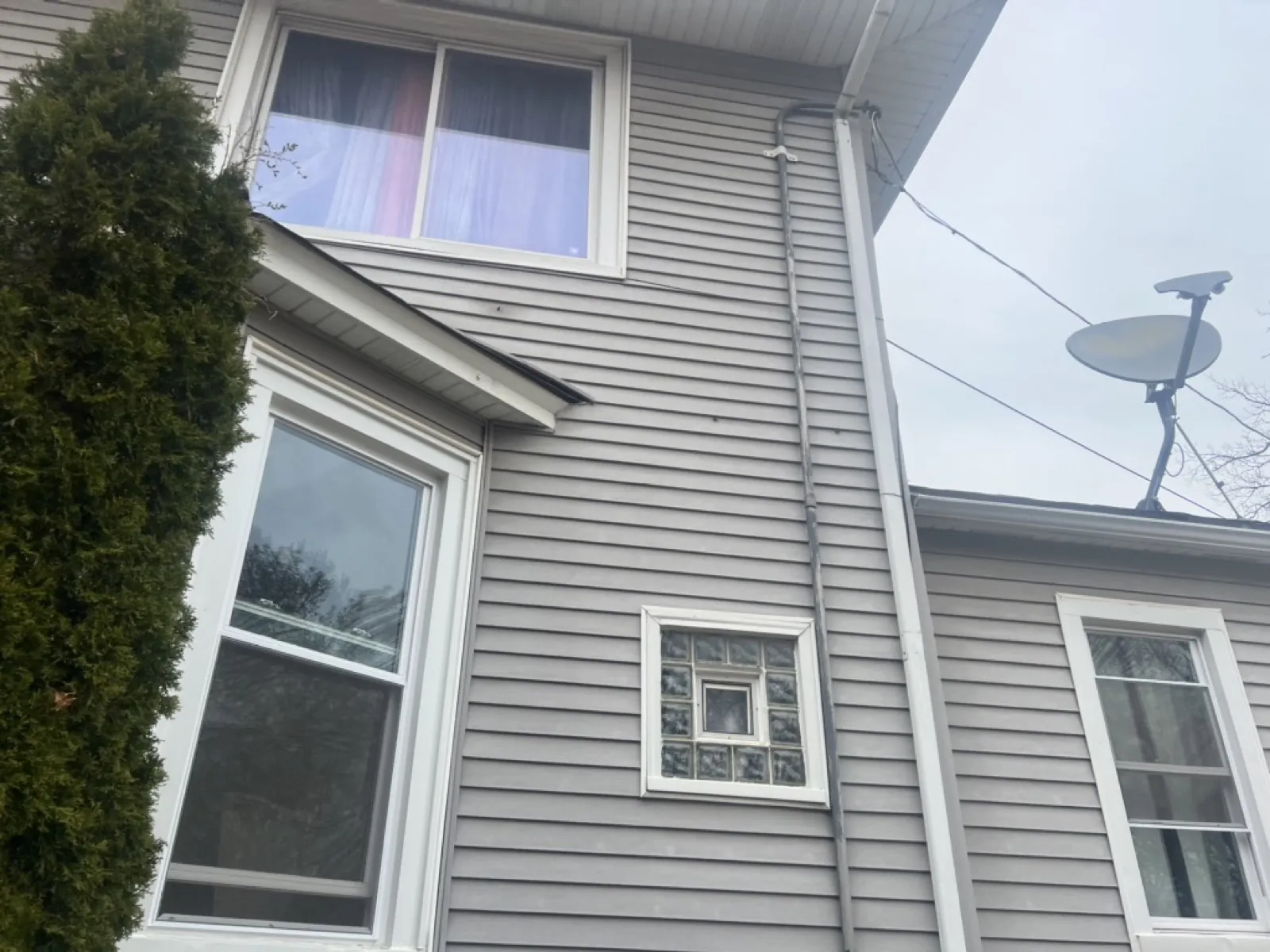 Gray vinyl siding installed on a multi-story home with white trim and windows in Maywood, IL