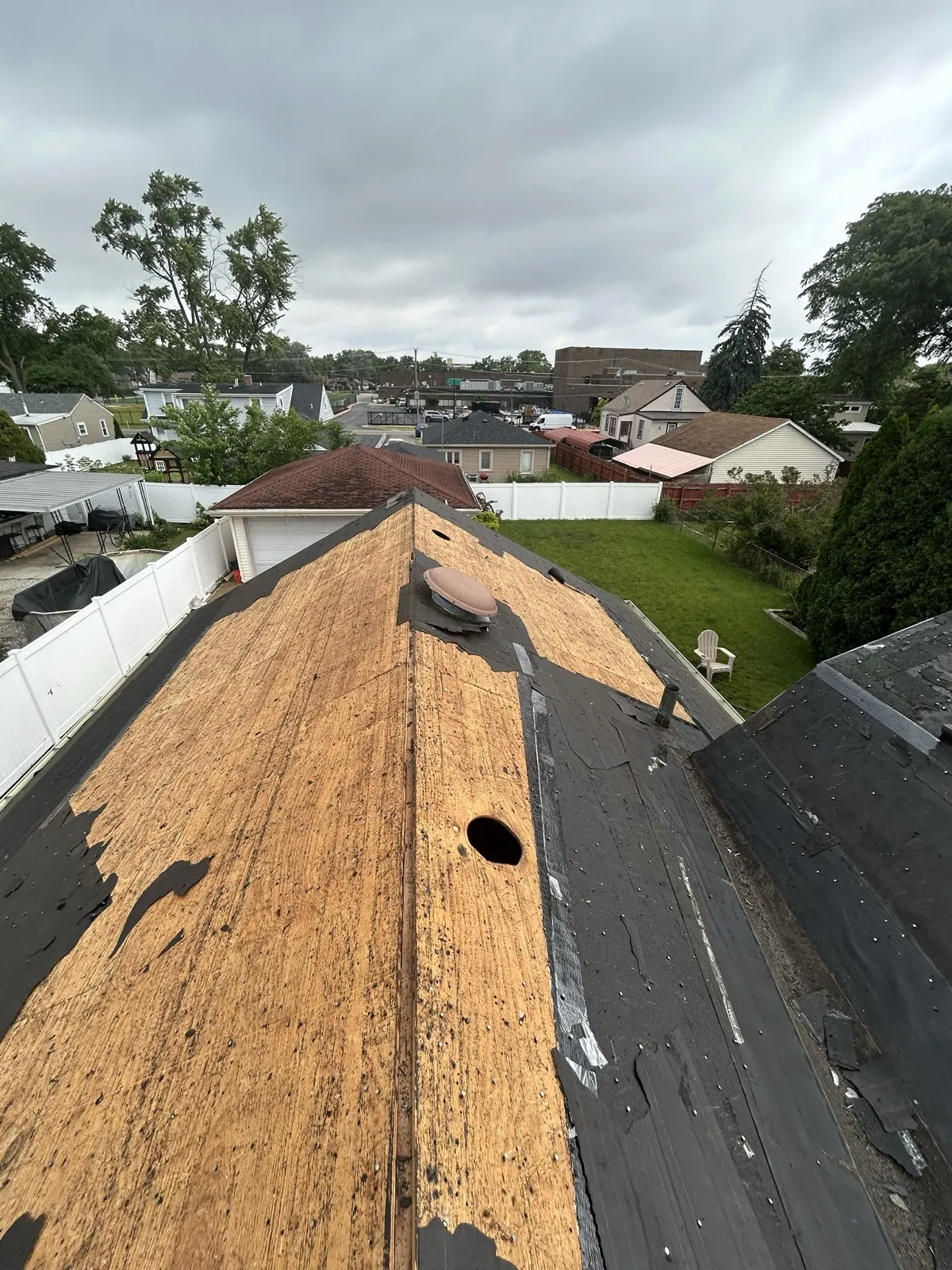 A roof replacement in progress showing exposed roof deck and partially installed asphalt shingles in Melrose Park, IL