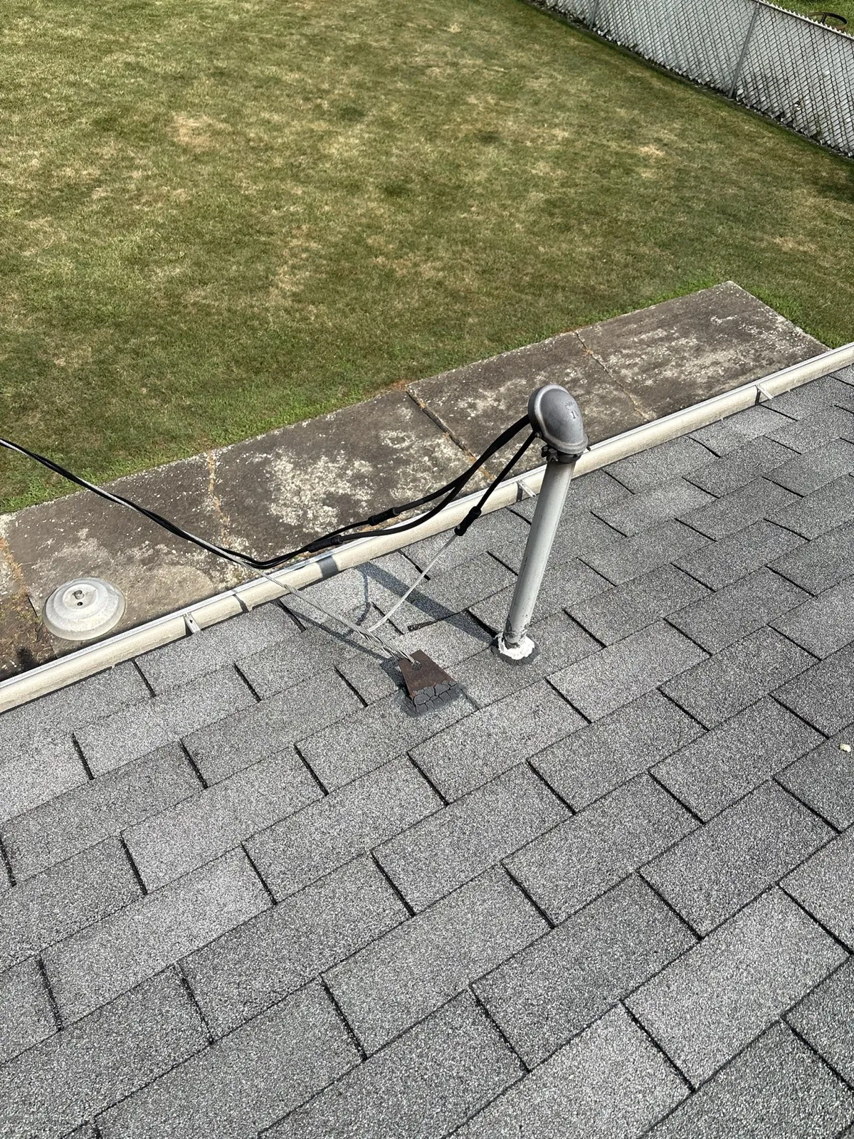 A close-up view of a gray asphalt shingle roof with a vent pipe and flashing in Midlothian, IL