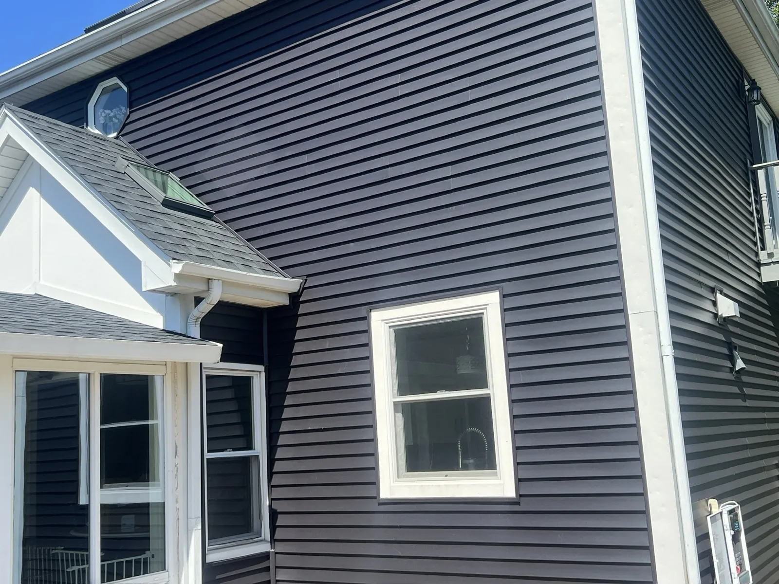 Dark navy blue vinyl siding on a residential home with white trim in Mokena, IL