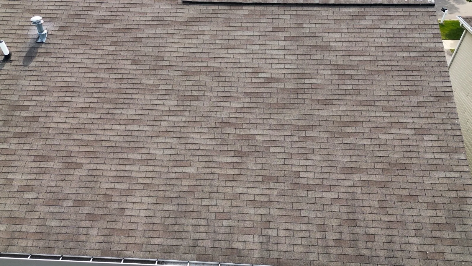 A close-up view of a brown asphalt architectural shingle roof in Montgomery, IL