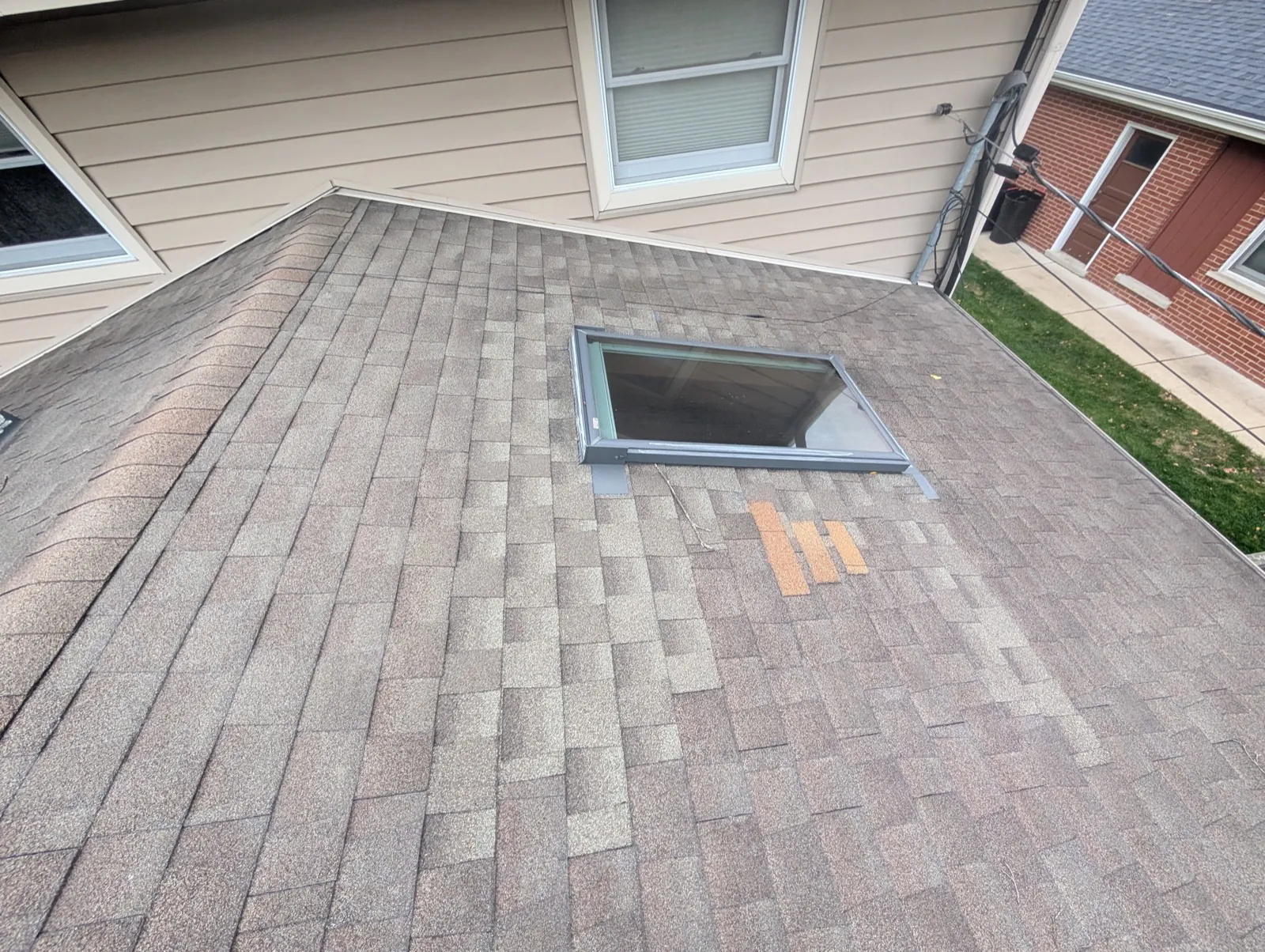 New brown architectural shingle roof with a skylight installation in Mount Prospect, IL
