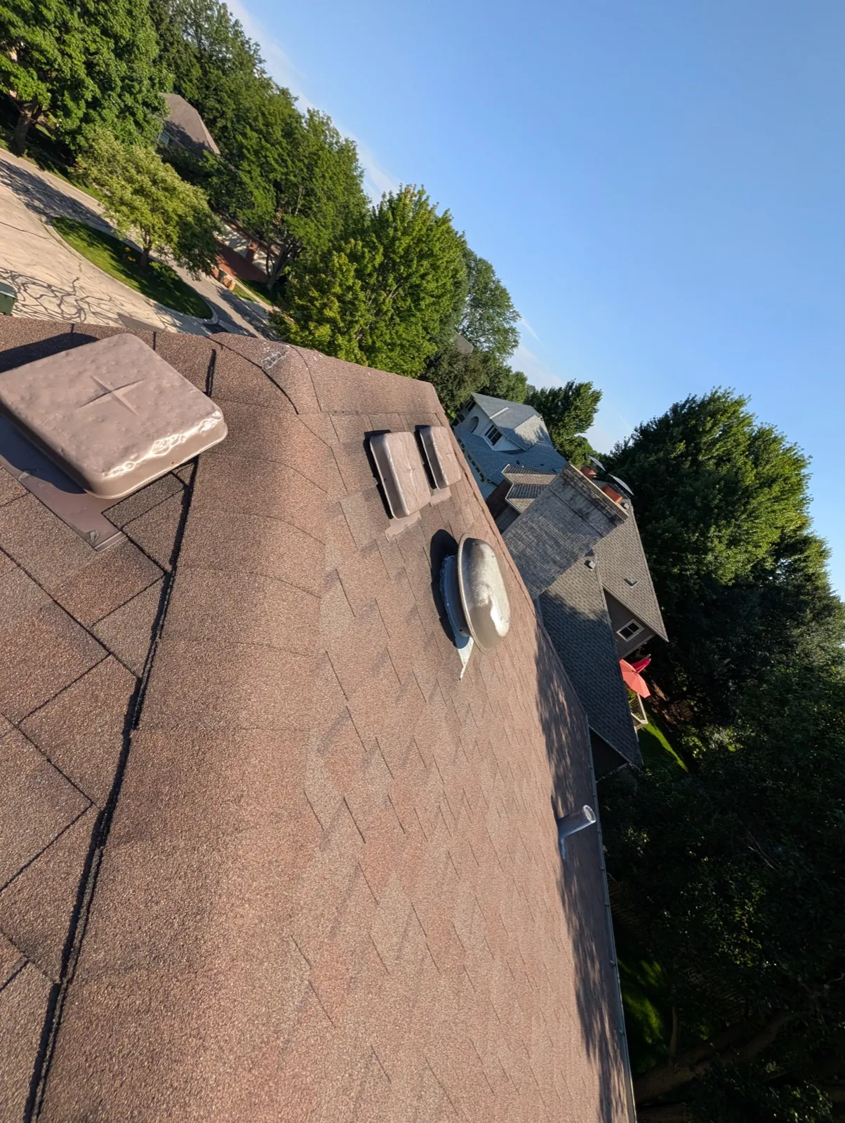 A brown asphalt architectural shingle roof with installed vents in Naperville, IL