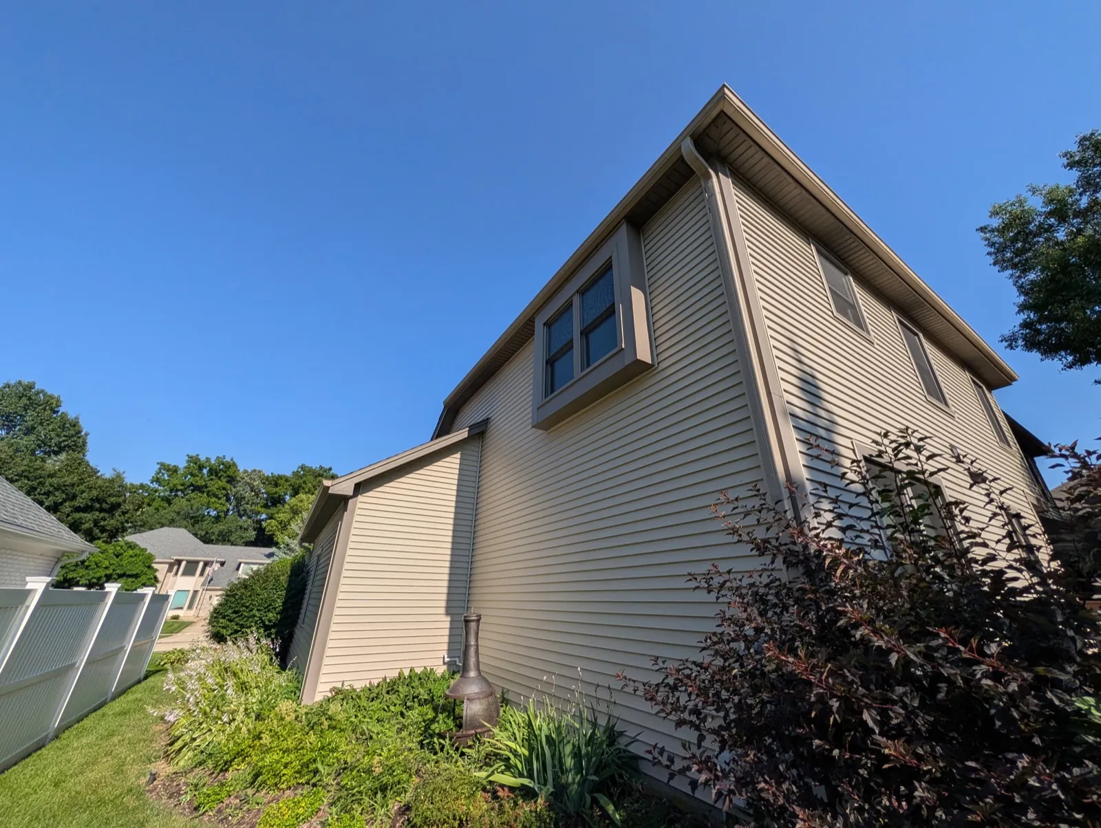 New beige vinyl siding on a two-story home in Naperville, IL