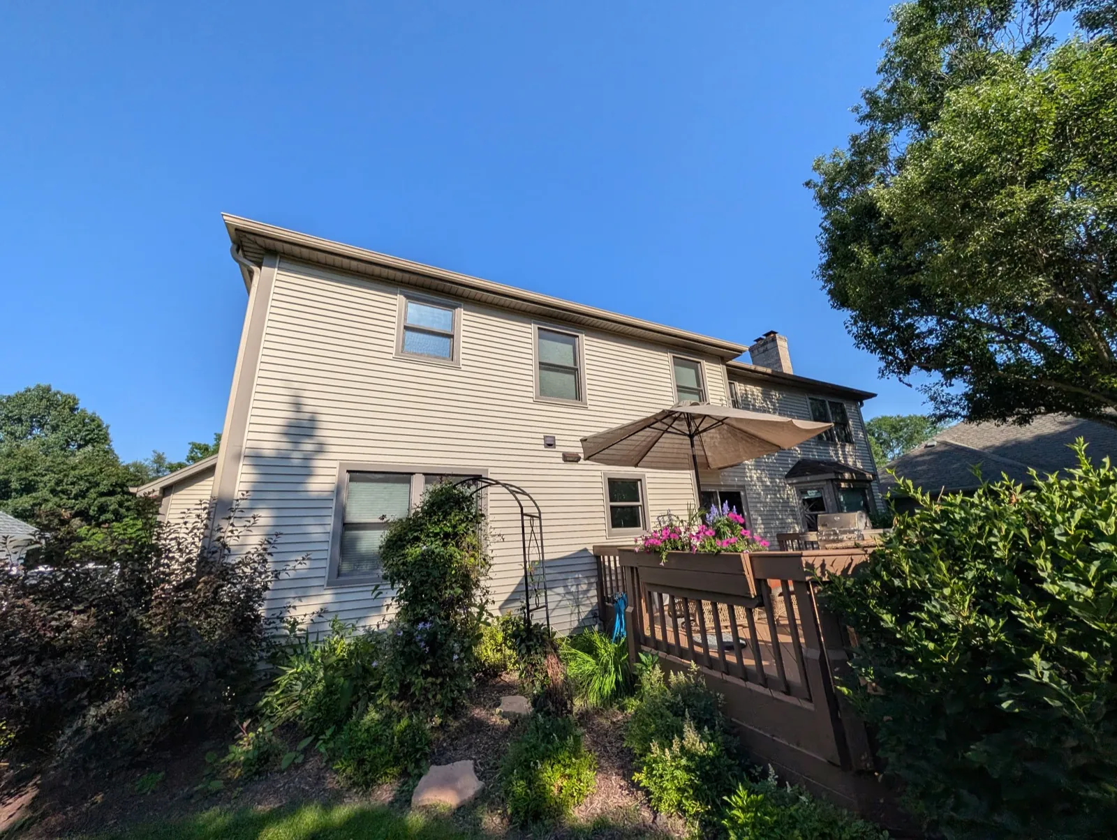 Beige vinyl siding on a two-story home with a wooden deck in Naperville, IL