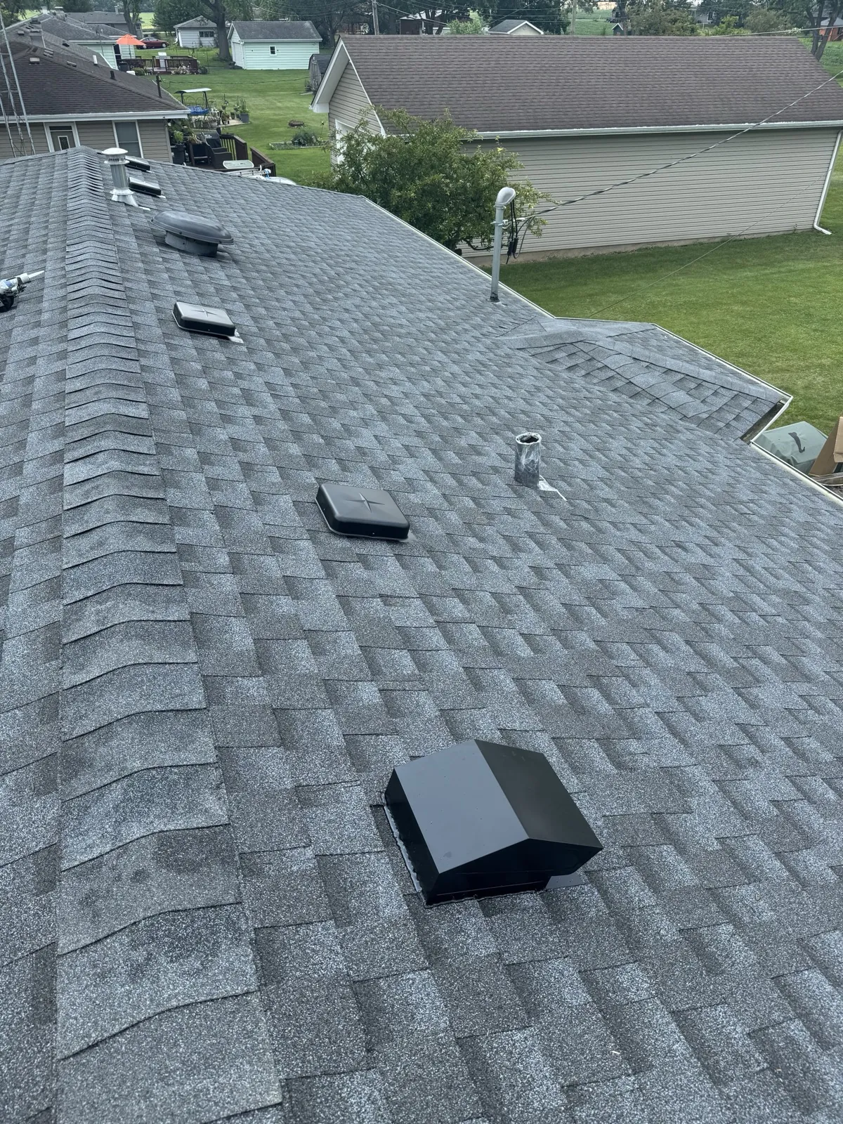 New charcoal gray architectural shingle roof with multiple skylights and vents in New Lenox, IL