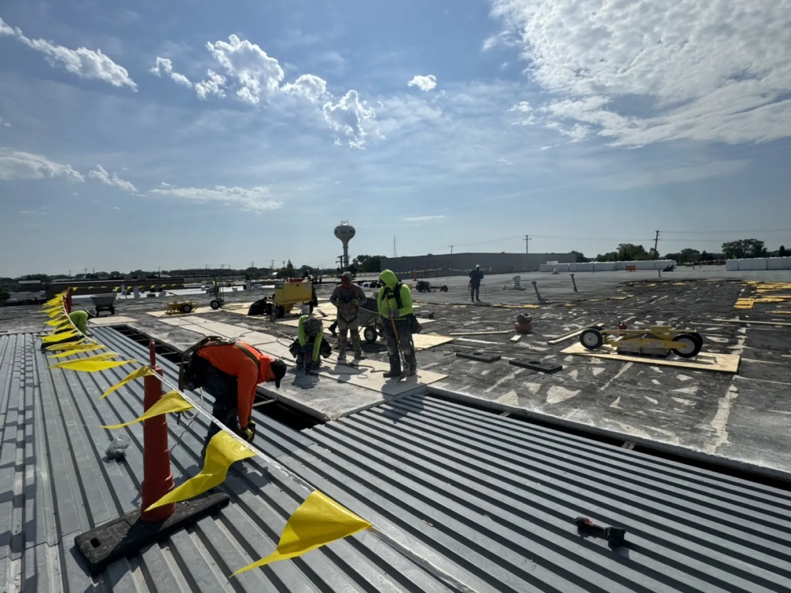 A roofing crew installing a metal roof system on a large commercial building in Norridge, IL