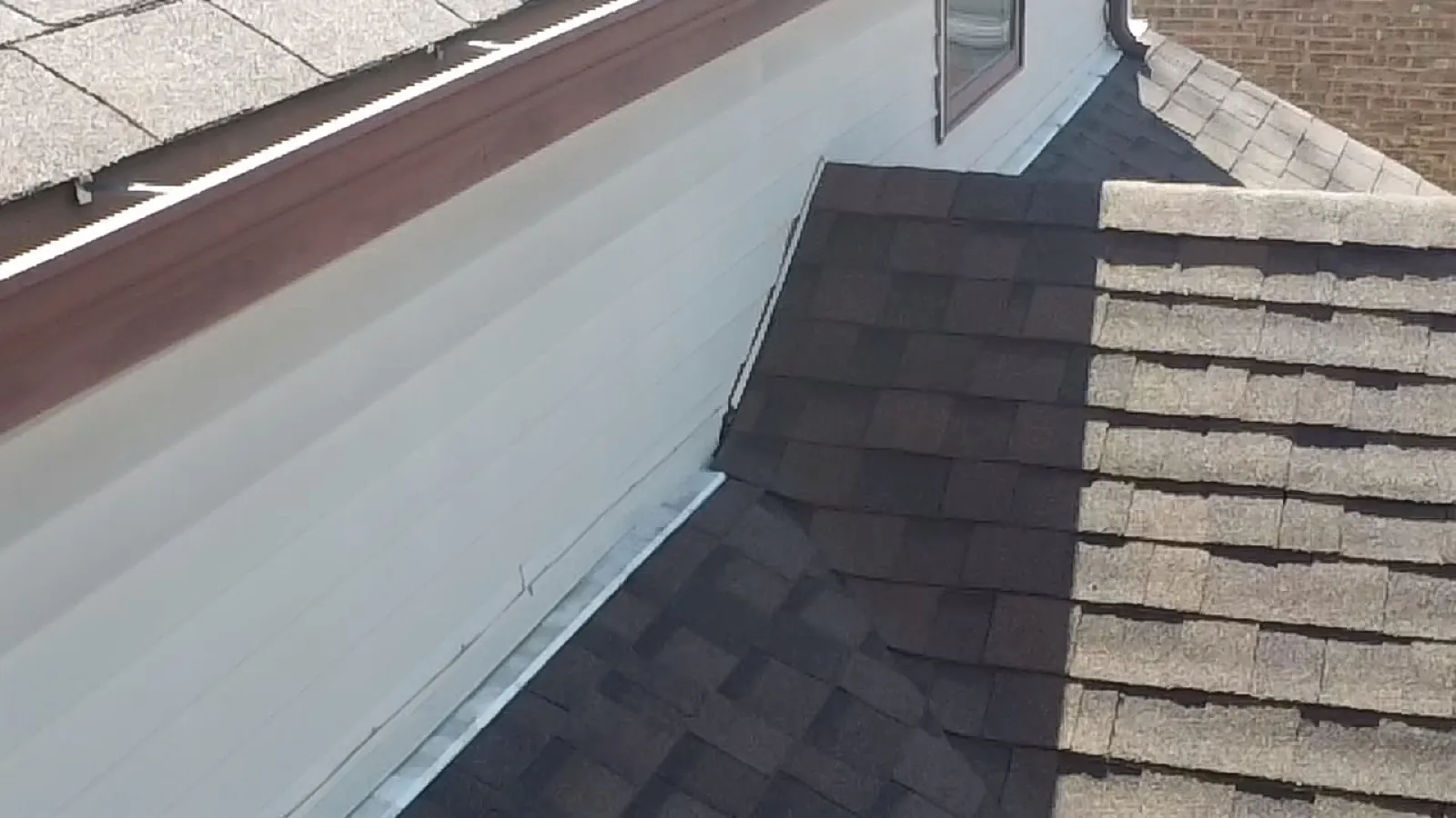 New charcoal architectural shingle roof installed on a home with white siding in Oak Lawn, IL