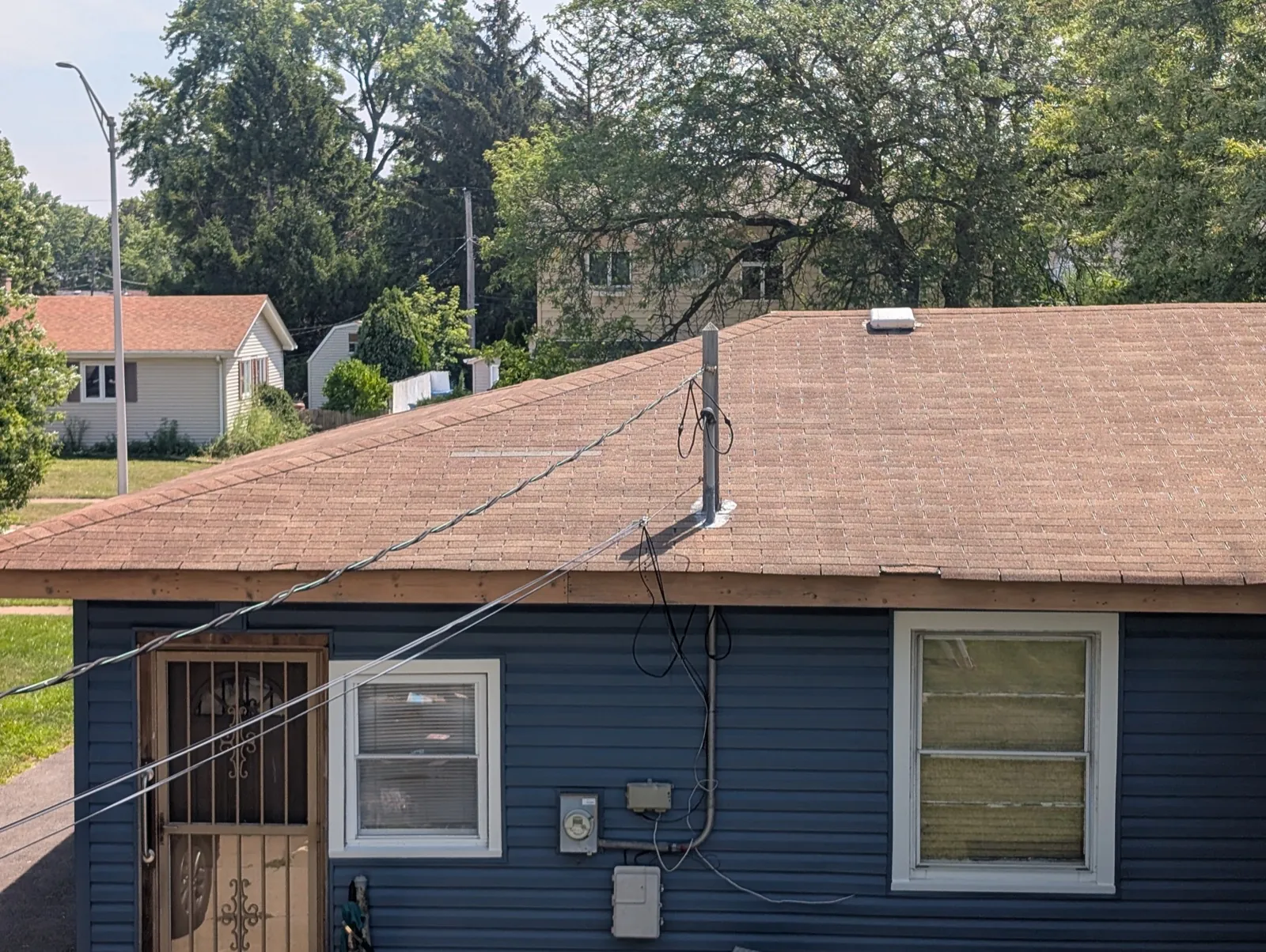 A brown asphalt shingle roof on a blue sided building in Oak Lawn, IL