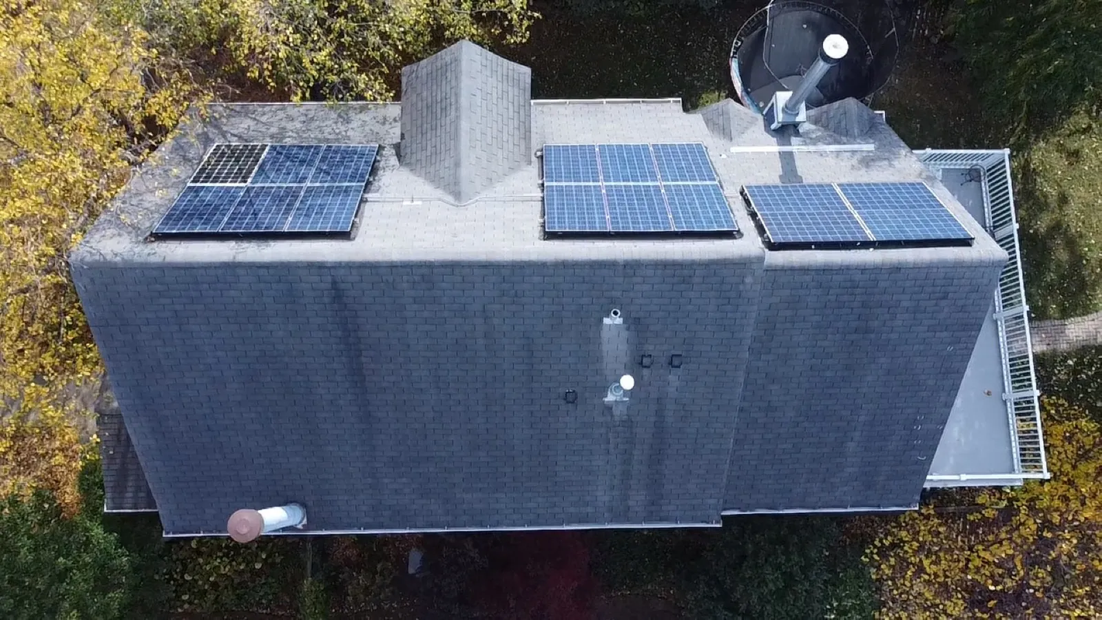 Aerial view of a gray architectural shingle roof with integrated solar panels in Oak Park, IL