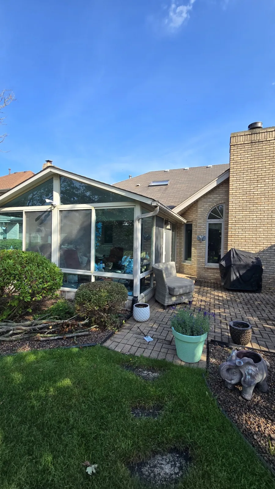 A multi-level home featuring a brown architectural shingle roof and brick siding in Orland Park, IL
