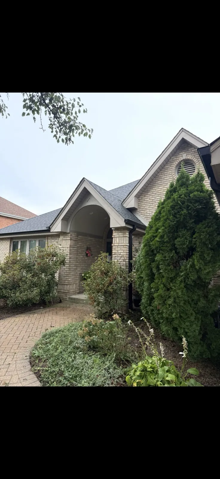 New charcoal architectural shingle roof on a brick home with a gabled entryway in Orland Park, IL