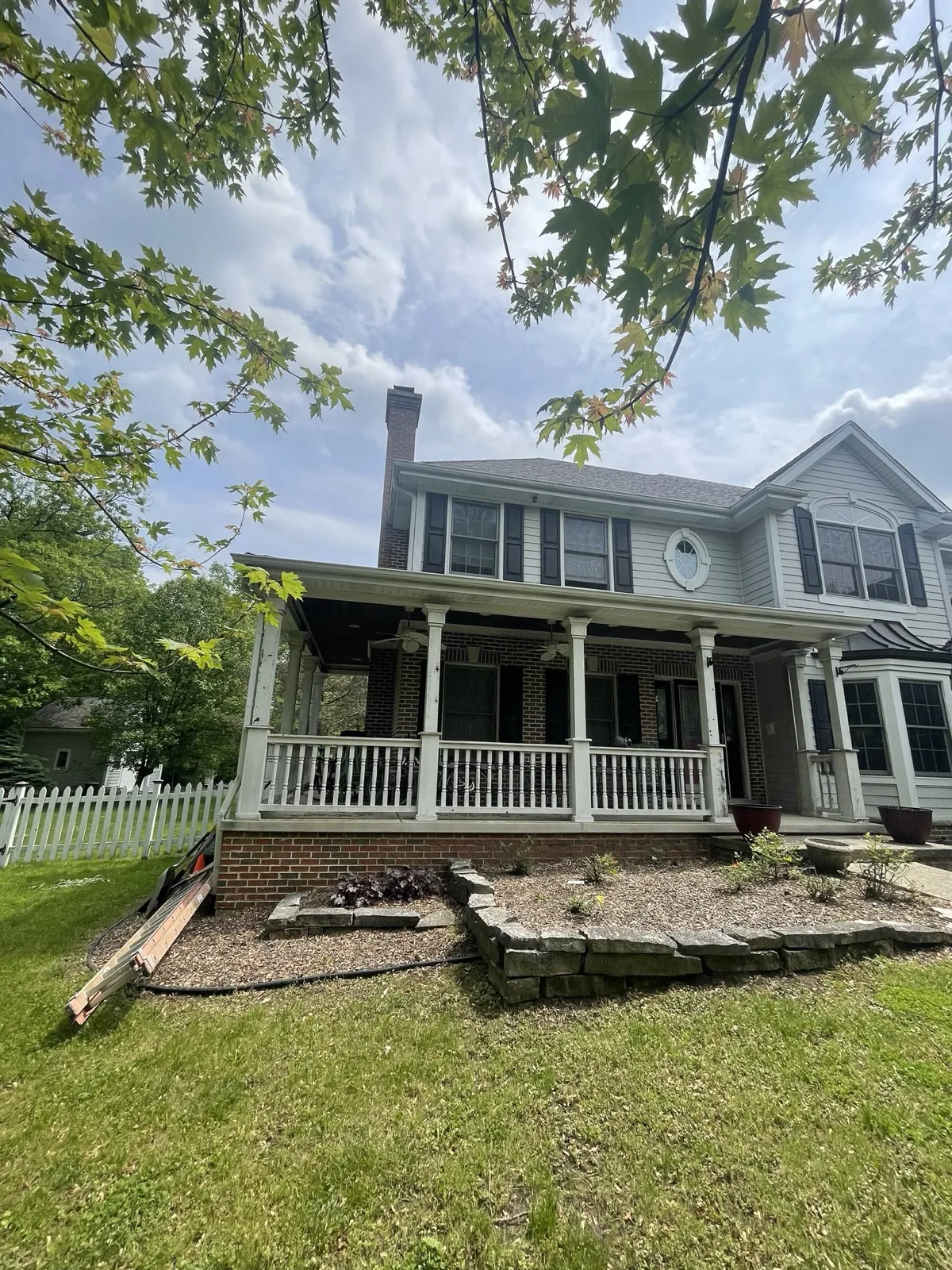 New charcoal architectural shingle roof on a two-story home with a large front porch in Palos Park, IL